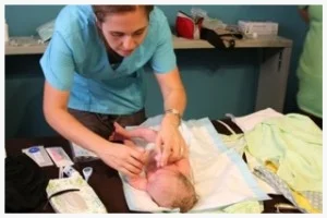 Celesta Bargatze does the work of a midwife by charting mother and baby's vital signs after delivery.