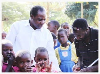 In the summer of 2011, Nyago John took his first trip back to Uganda since moving to the US in 2008. Here, he re-visits the elementary school where he attended, signing the guestbook and greeting the headmaster and children.