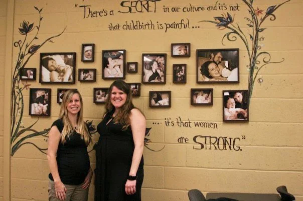 Tara Garner and Jen Nyago, both pregnant, stand in front of a collage of women educated by the NOVA program. This collage is a testimony to the joy of childbirth and the strong network of support for childbearing women within our movement. Since this photo, both Tara and Jen have delivered healthy babies in the peace and comfort of their own homes.