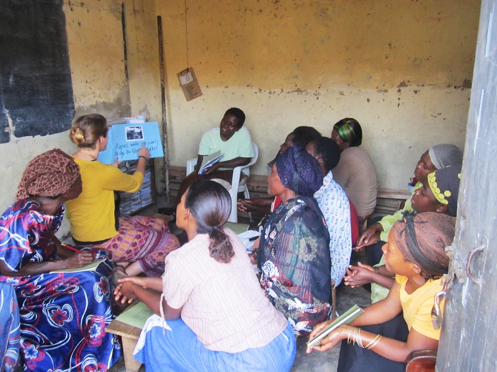 Ashley Moore teaches her women's literacy class in the Bwaise slum (located outside of Kampala) using a technique called "Big Book Literacy." The technique is used to help students gain confidence reading in the safety of a group. She created the book herself, using pictures and stories of every situations experienced in Bwaise.