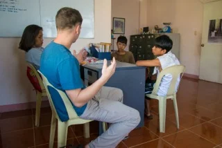 Jason Carpenter teaches on Jesus' feeding of the multitudes out of John at a local center for youth, while a friend translates.