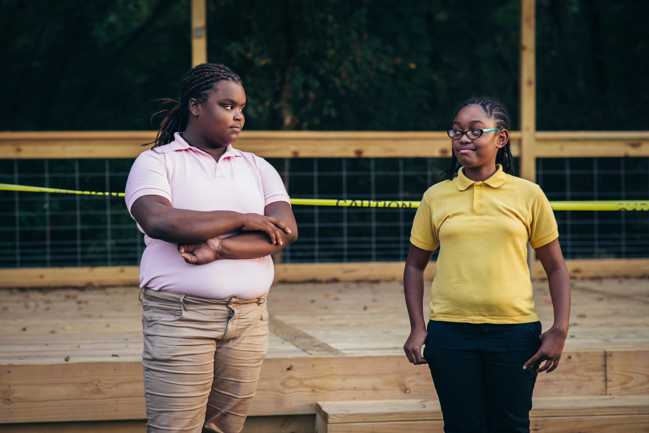 Practicing facial expressions, two workshop participants trade serious stares.