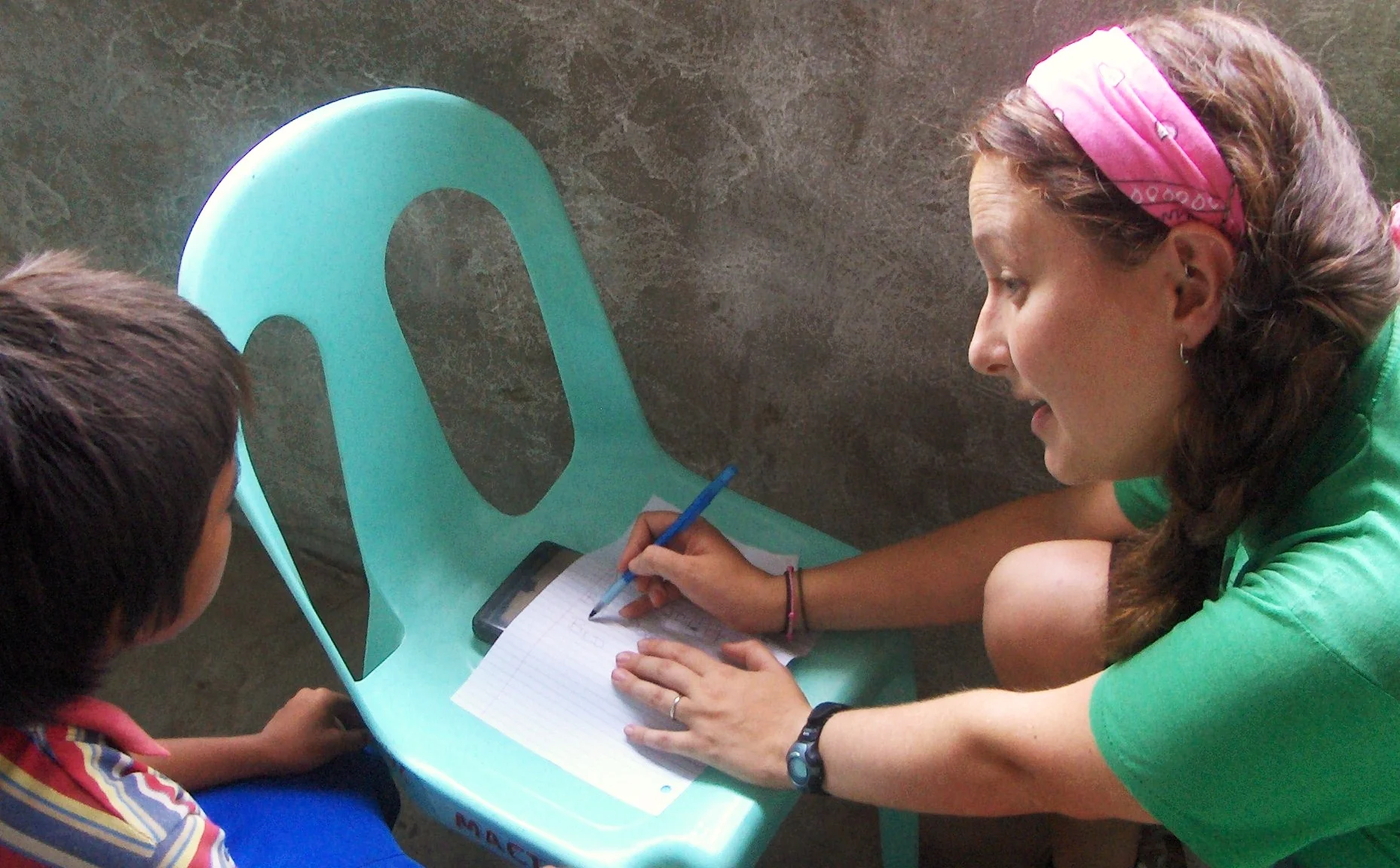 Candace Galford helping a young boy with reading in the Lapu Lapu City dumpsite. The boy's parents work at the dumpsite, scavenging through trash to recycle for income--sadly, a livelihood for many people in the Philippines. 