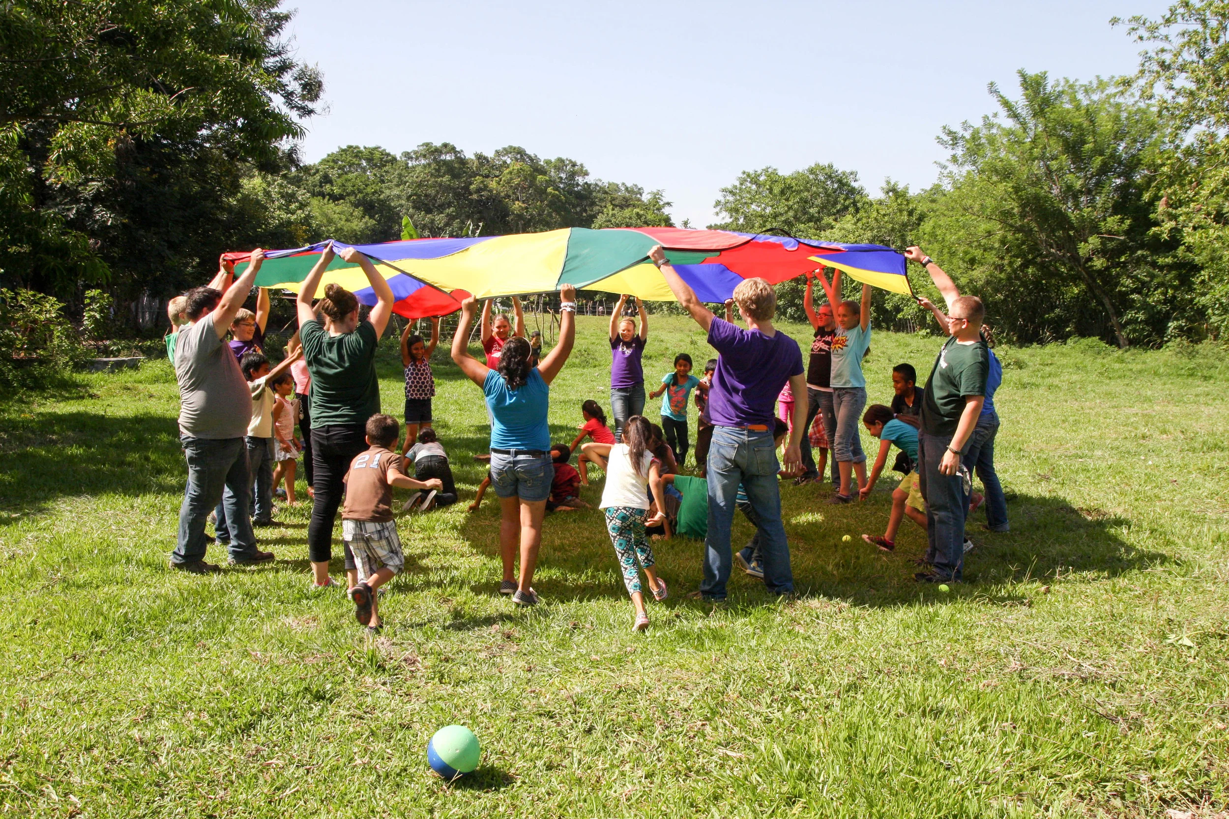 Camp Skillz El Salvador engages the local children with a game of parachute. 