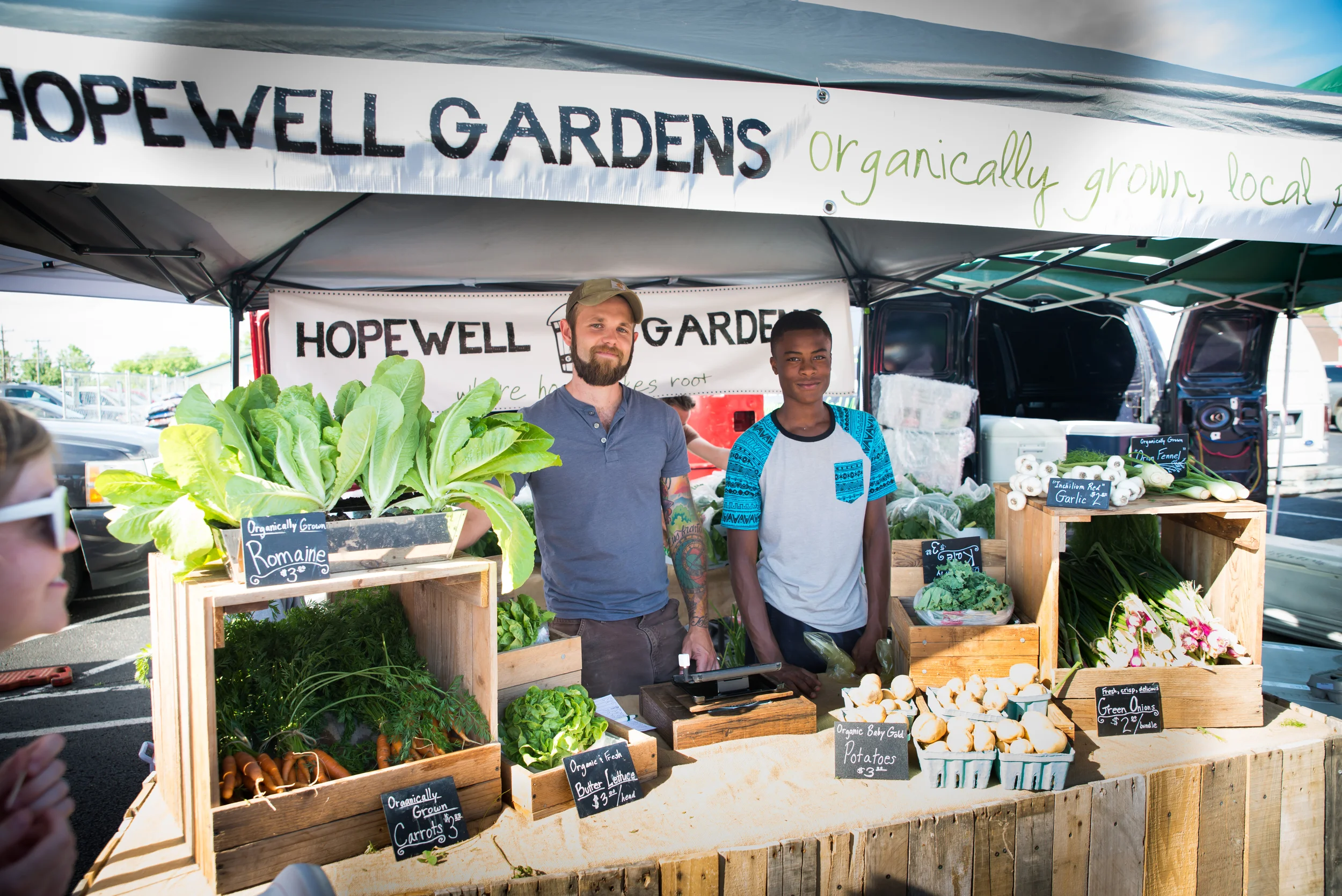 Geoff Hartnell, our farm manager, and Gerron Norman represent our community garden at the local farmer’s market. Gerron, 15, lives in our neighborhood and volunteers 3-4 times a week in our garden. Since he’s begun volunteering, he has used his new skills to start his family’s own backyard garden. 