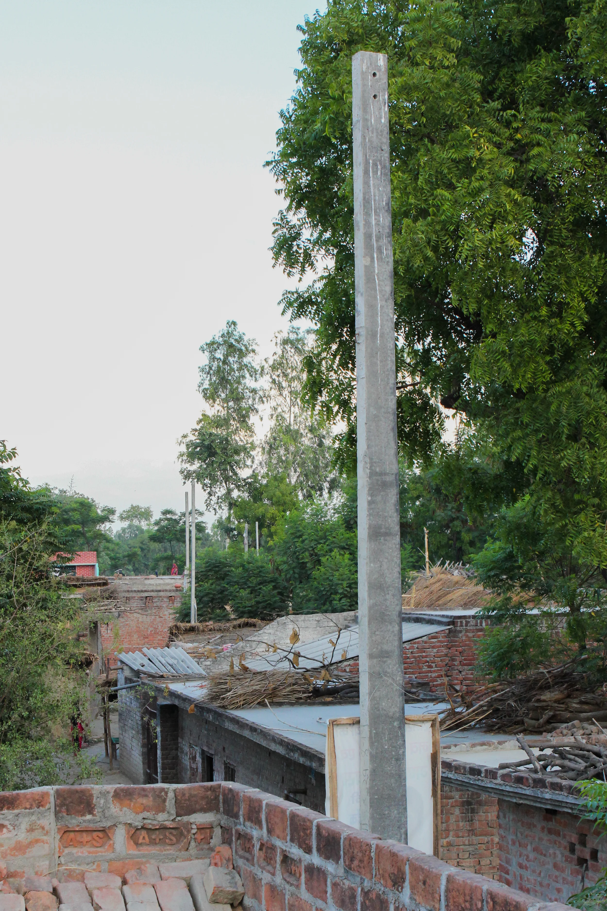 Villages near urban centers are often neglected by local utilities. Though the government installed concrete poles for power lines in this village on the edge of Lucknow (a city of over 5 million), the people were still without electricity eight months later, when we visited.