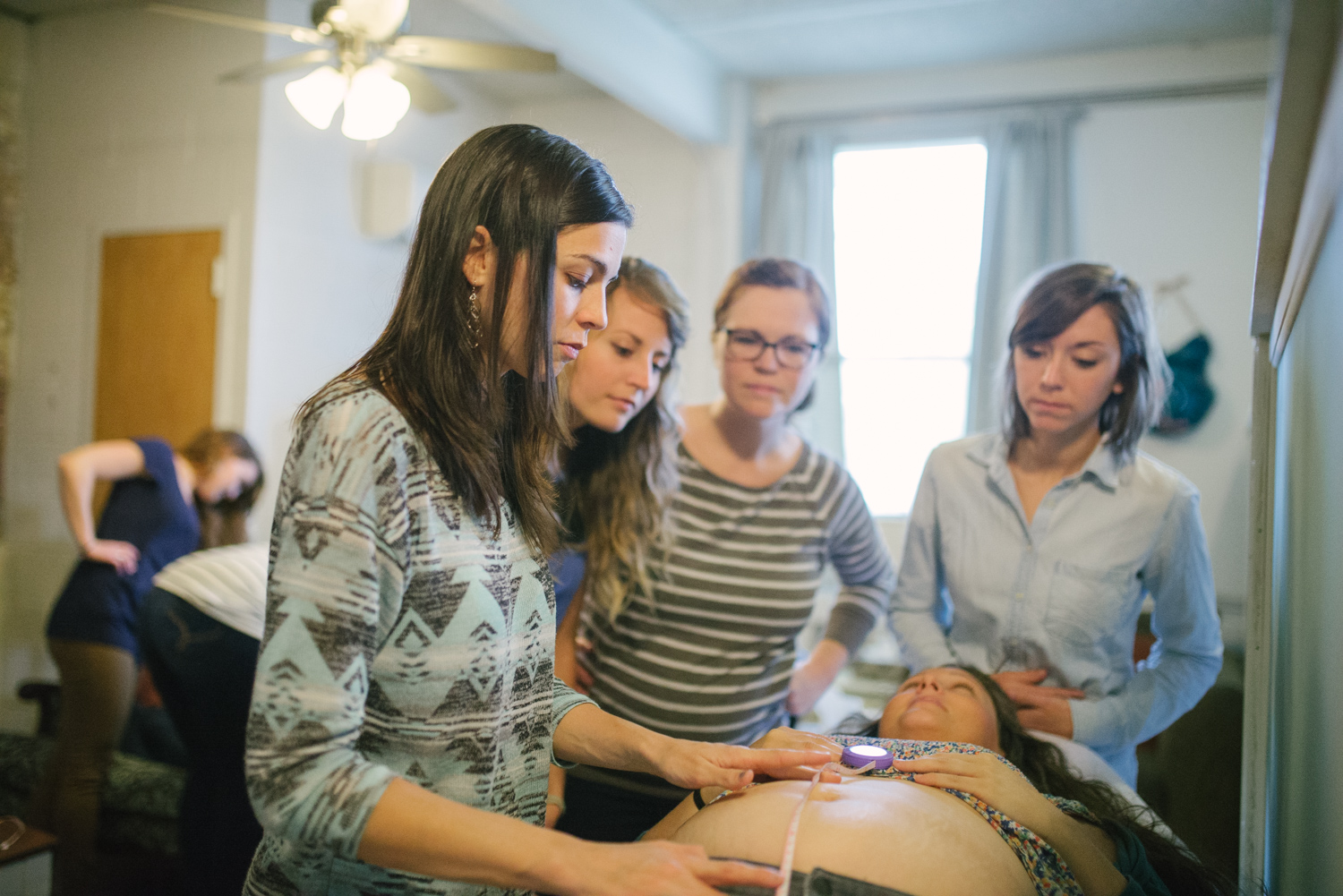 Heather Munoz shows CBE students how to measure fundal height on a live pregnant model. Many of our students go on to become doulas, childbirth educators and midwives. 