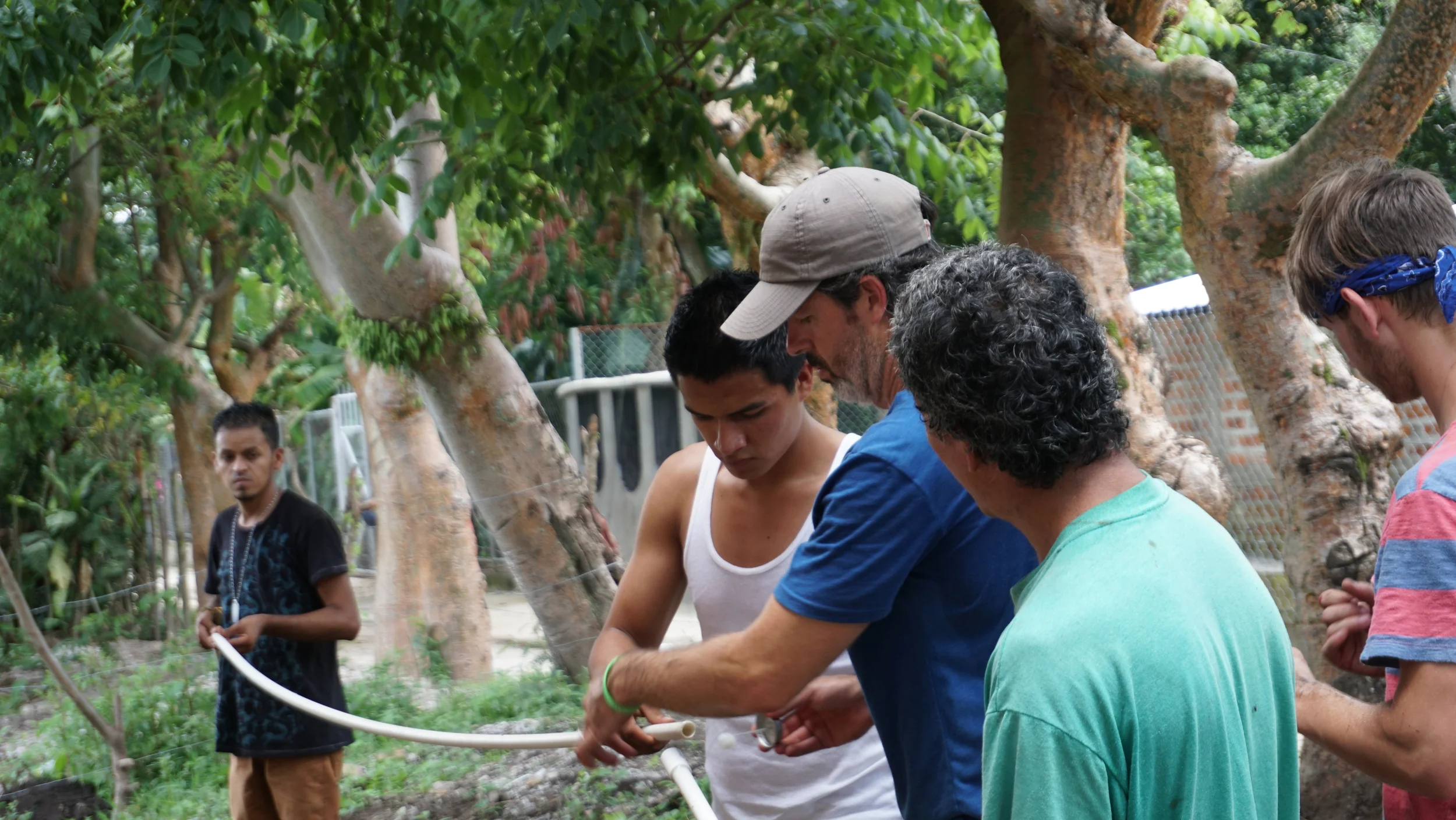 Billy Fly (blue shirt) works with Salvadoran youth to help connect the water line that will run to Noe's (green shirt) house to give him running water. 