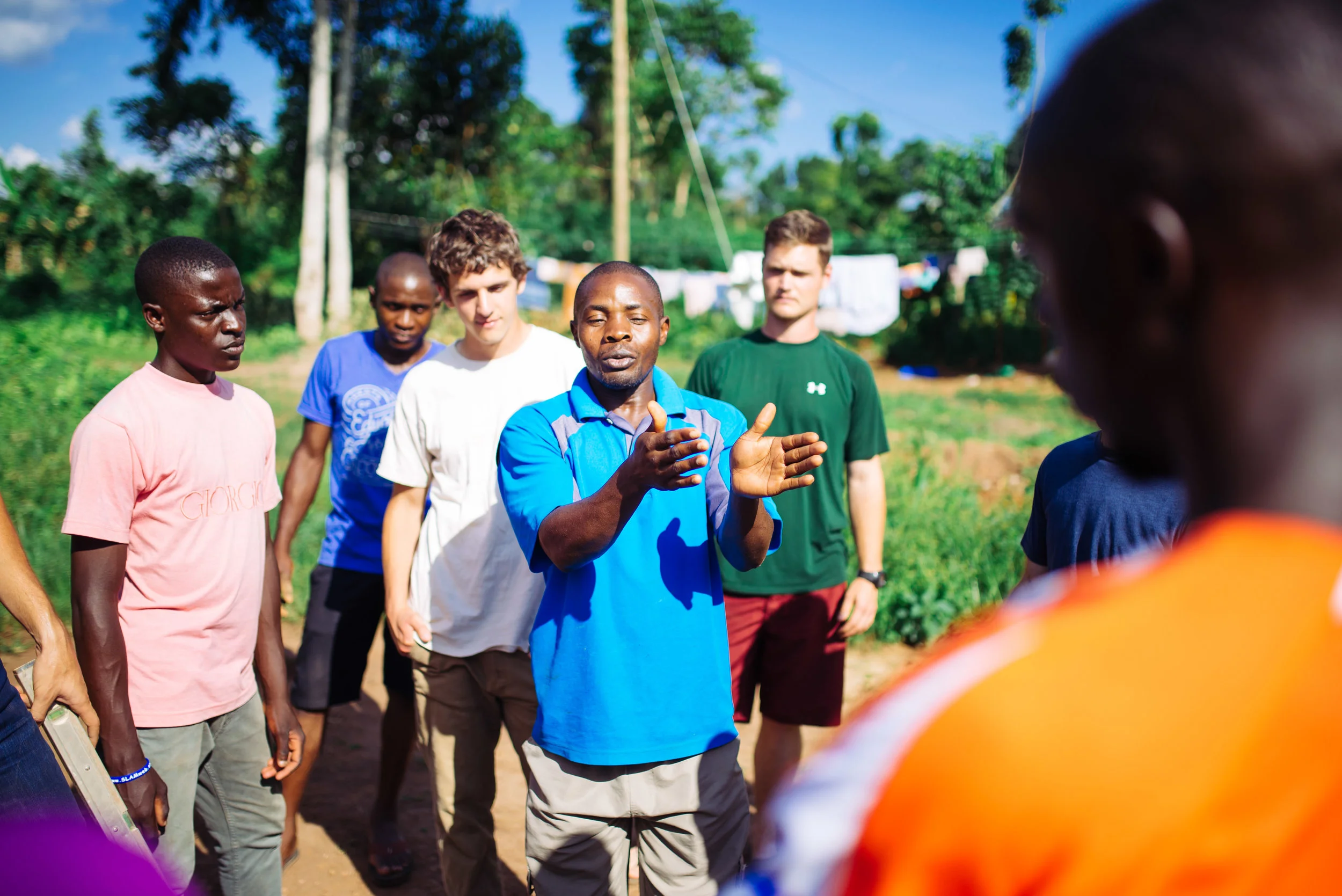 Francis Lubega instructs a small team on how to build rocket stoves and their benefit in homes in rural Uganda. 