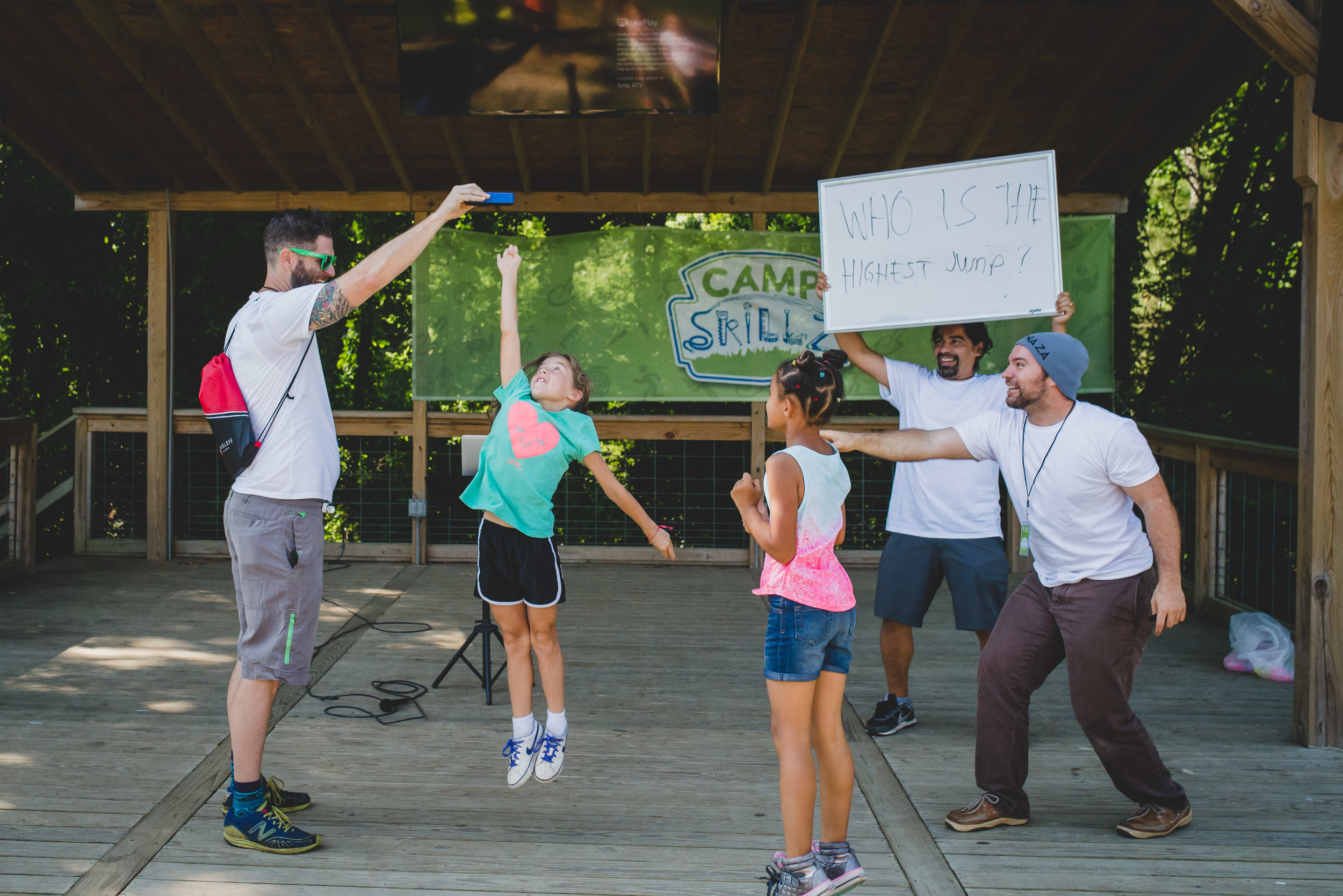 Academy parent and volunteer extraordinaire John Edmondson helps facilitate camper contests at the Camp Skillz kick off, measuring "how high," followed by how fast and how strong, from the Camp Skillz motto: Higher, Stronger, Faster. 