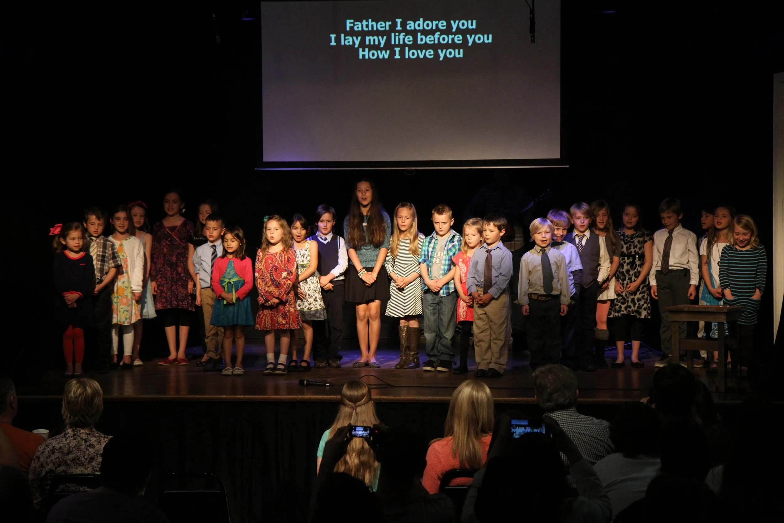 In the Academy's first year, the entire student body could fit on the stage. Here, they performed for the first supporter/grandparent event, titled "Come and See," referencing Jesus' words that demanded the faith to come and experience something before it was widely known. 