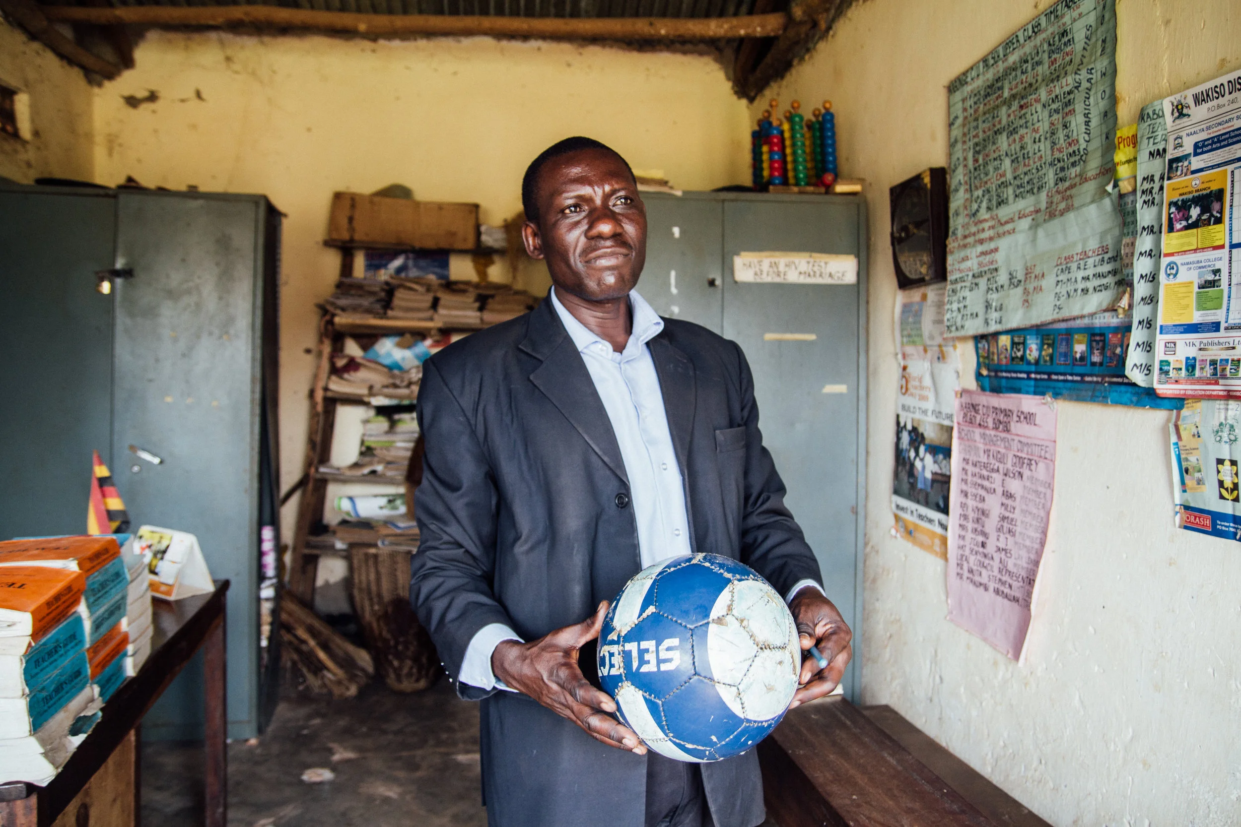 HM Stephen Kawuta in his office at St. John's Primary, holding one of the first footballs ever gifted to the school. 