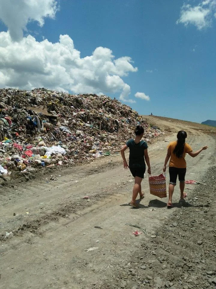 Volunteers from Tahanan carry food to workers at the Tacloban dumpsite. 