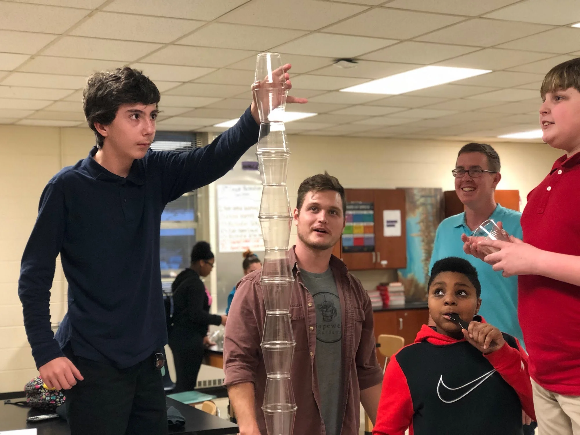 Brett and volunteer Colin work together to garner a healthy and safe environment in the CASE program. Here, students are working on team building through a cup stacking game.