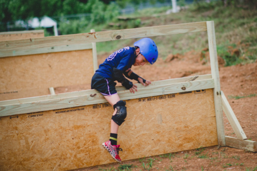 Camper Evan Olascoaga is encouraged to muscle through the obstacles in the mud course in order to develop his sense of grit: having the passion and resolve to complete a goal.