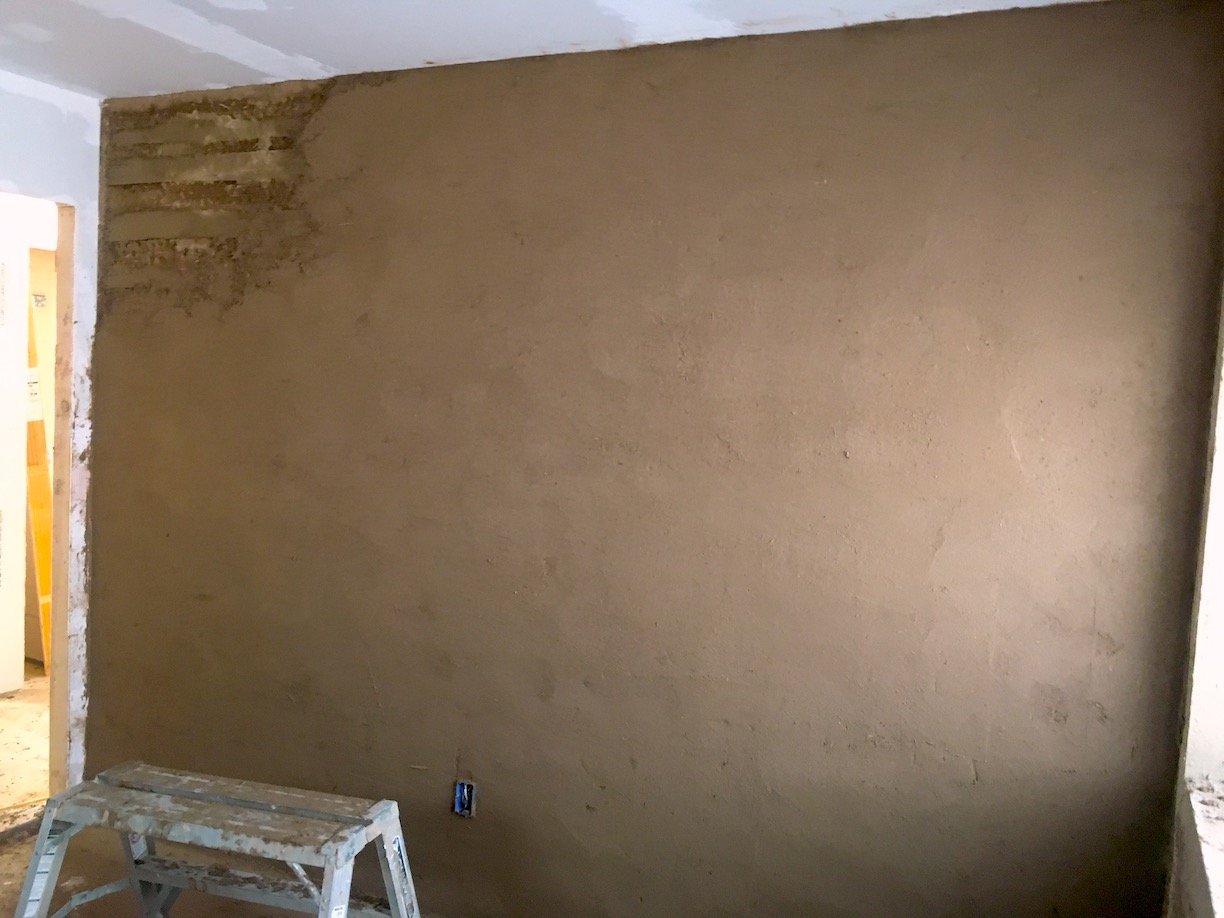  Process shot of brown coat plastering interior walls. 