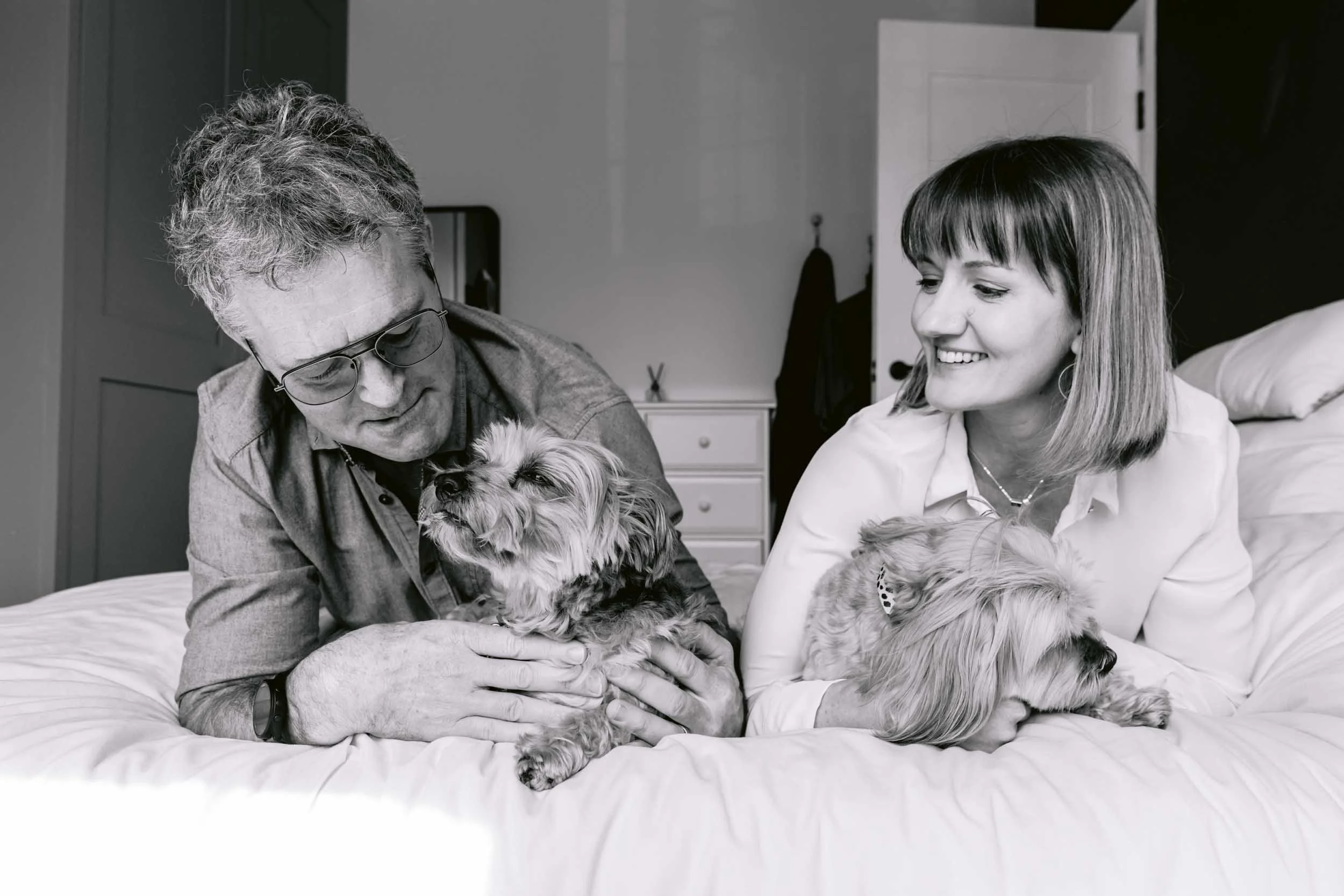 Owners cuddling their senior dog during a relaxed pet photography session focused on preserving meaningful memories.
