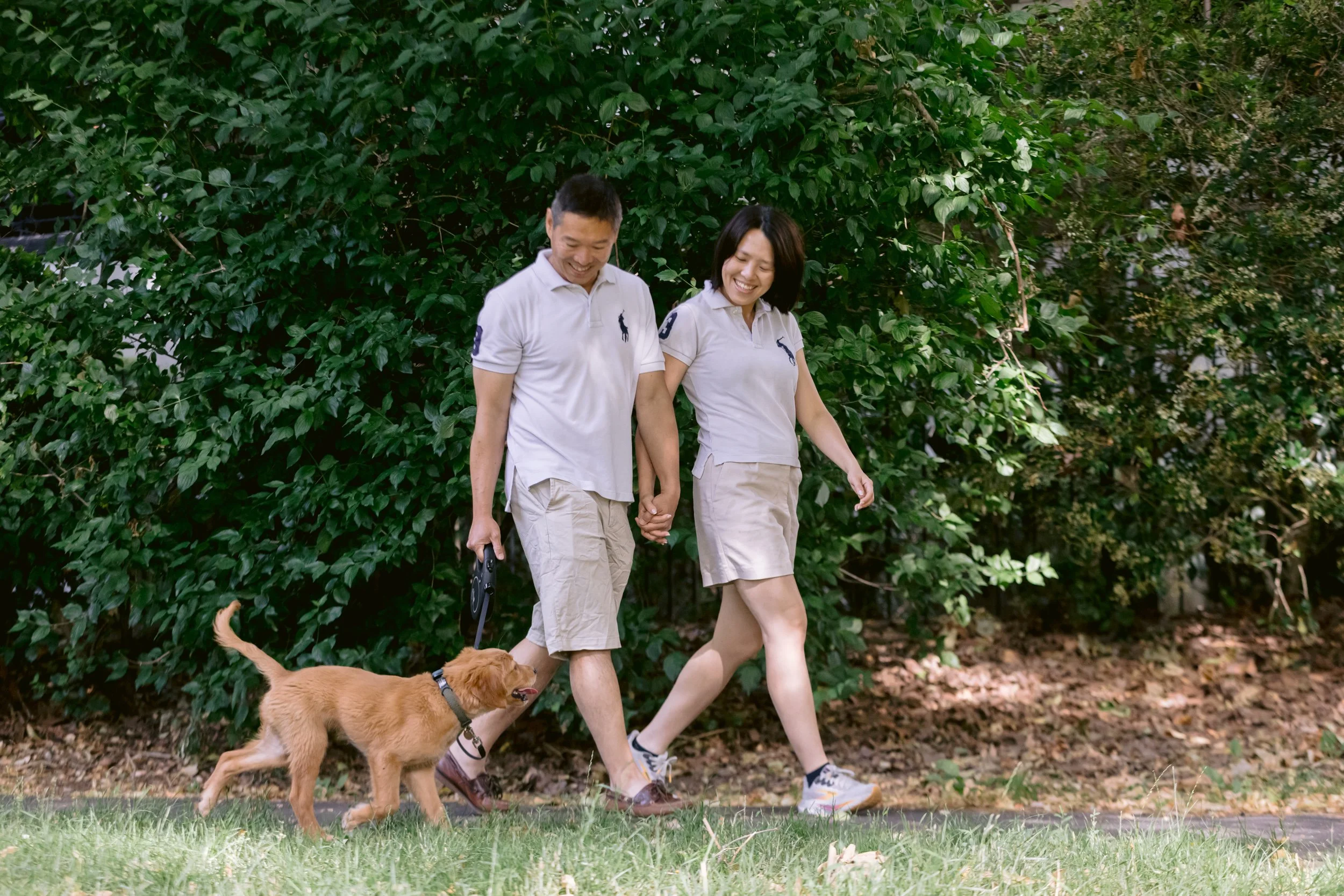 A couple walking with their golden retriever puppy during a photo session in Chelsea, London