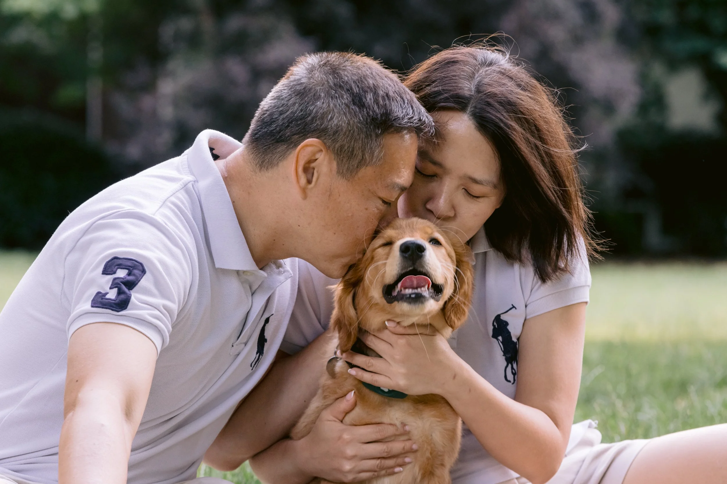Couple kissing their puppy during a photo session in Chelsea