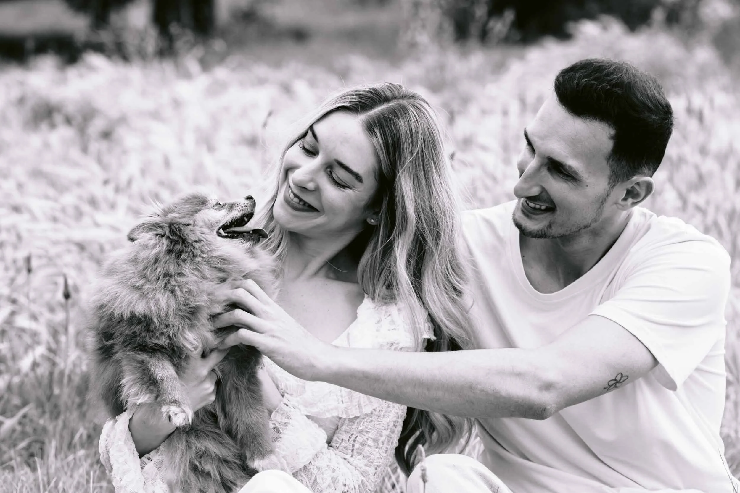 Couple cuddling a pomaranian on Clapham Common in London