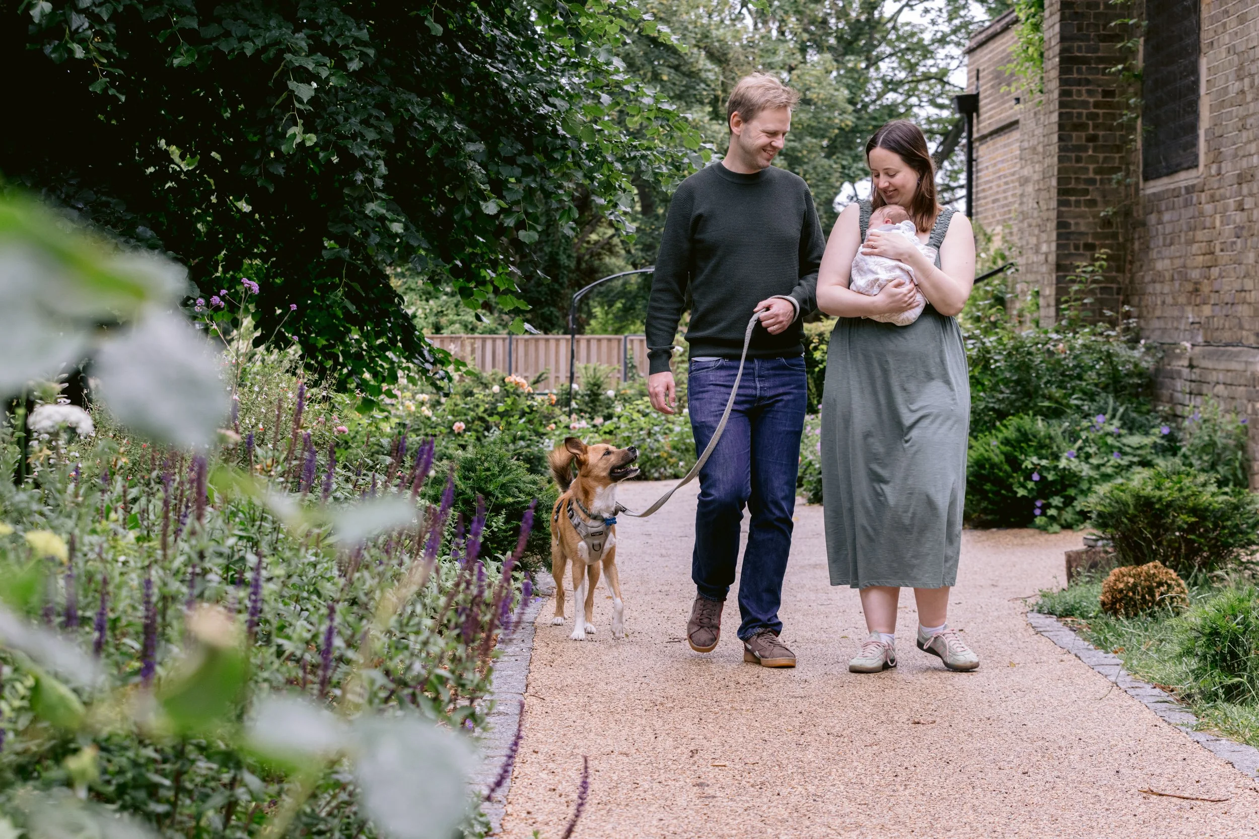 Family walking with their dog and newborn baby in Putney, London