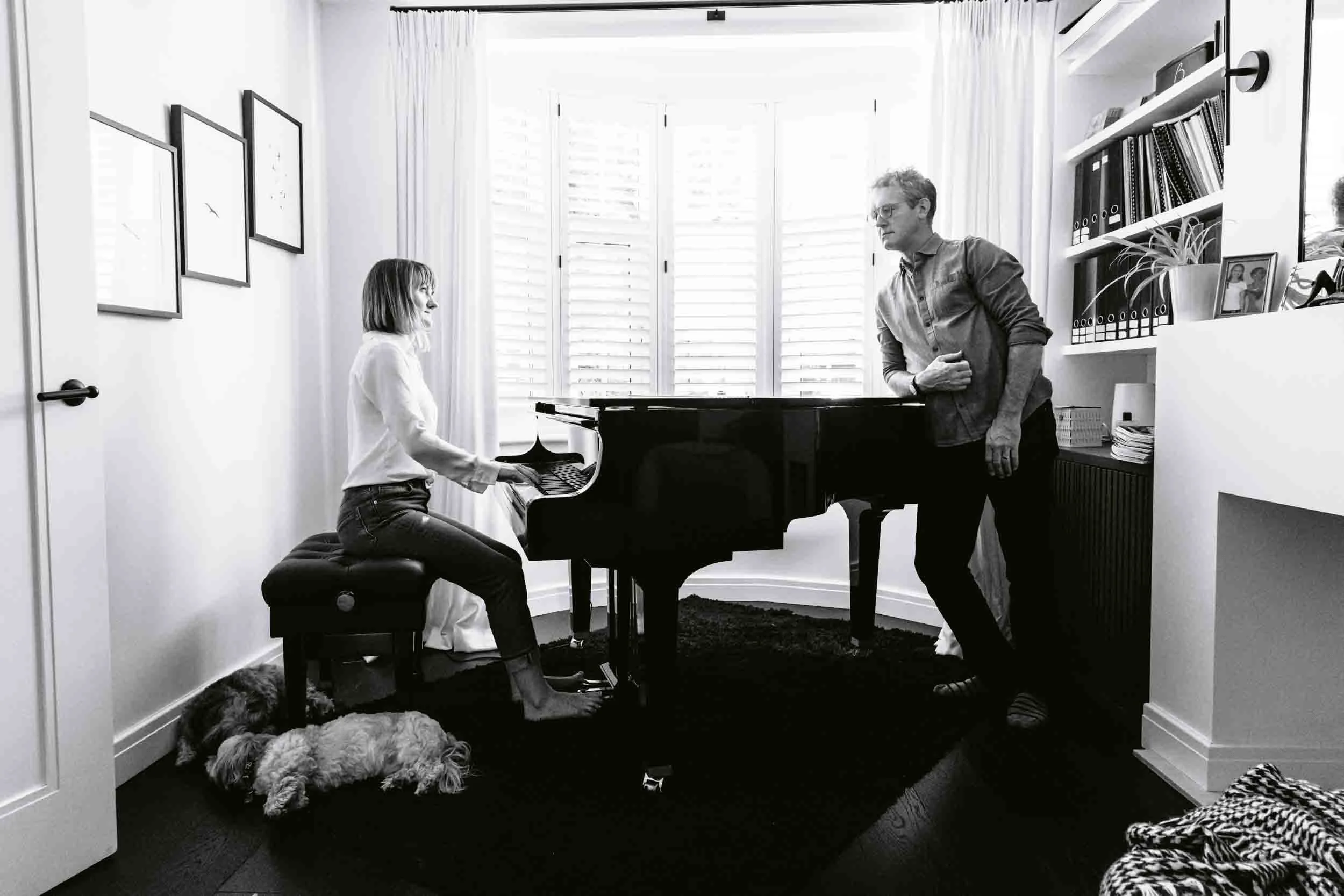 Senior dog rests beside owner playing the piano in an end-of-life pet photography session in London