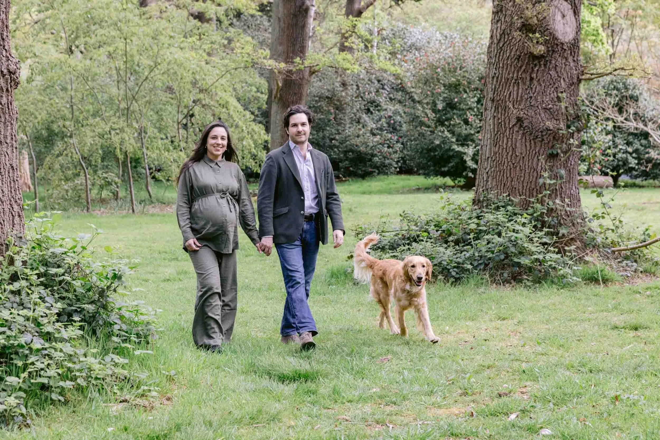 Couple and their dog walking during a woodland maternity portrait in Isabella Plantation, London