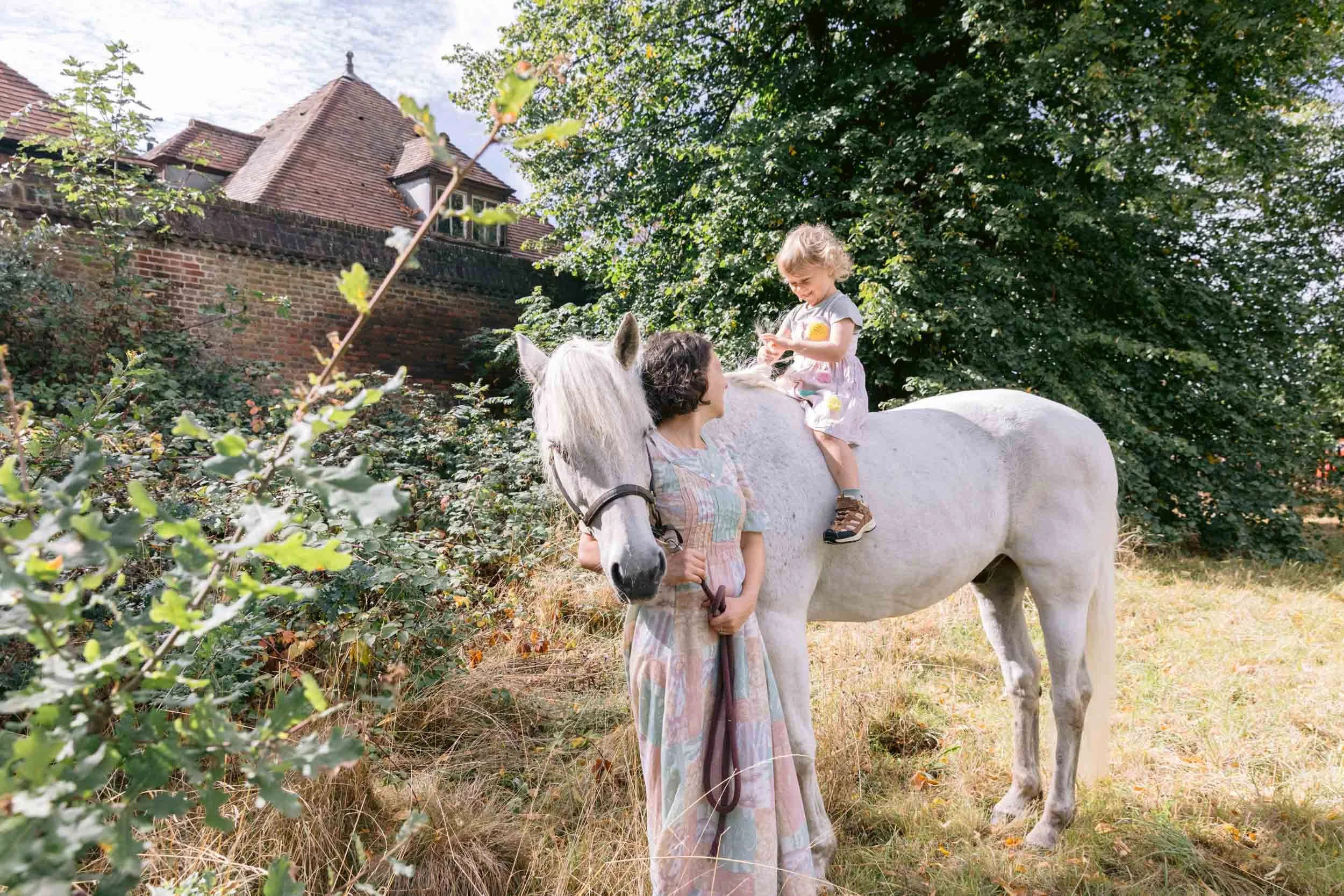 A mother celebrating Mother's day with a family portrait with a dog and horse