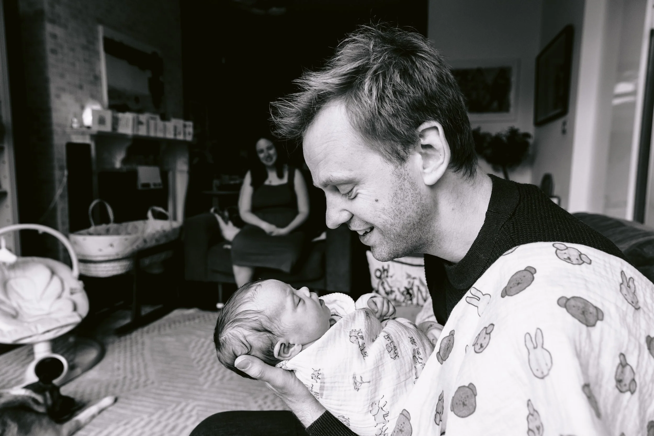 Dad cooing over newborn baby during an in-home newborn photo session in London