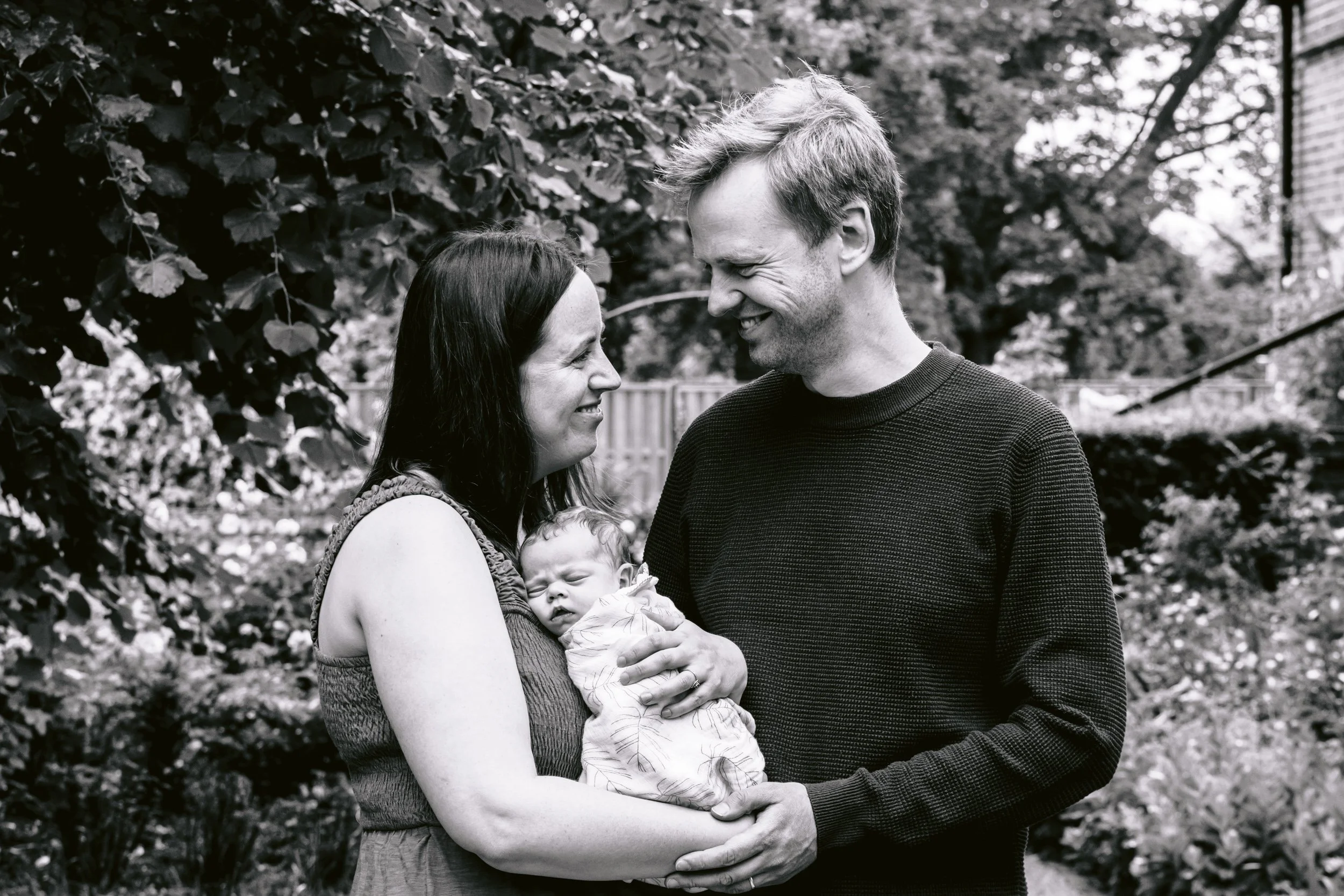 Family smiling and enjoying each other's company during a newborn photo session in Putney, South West London