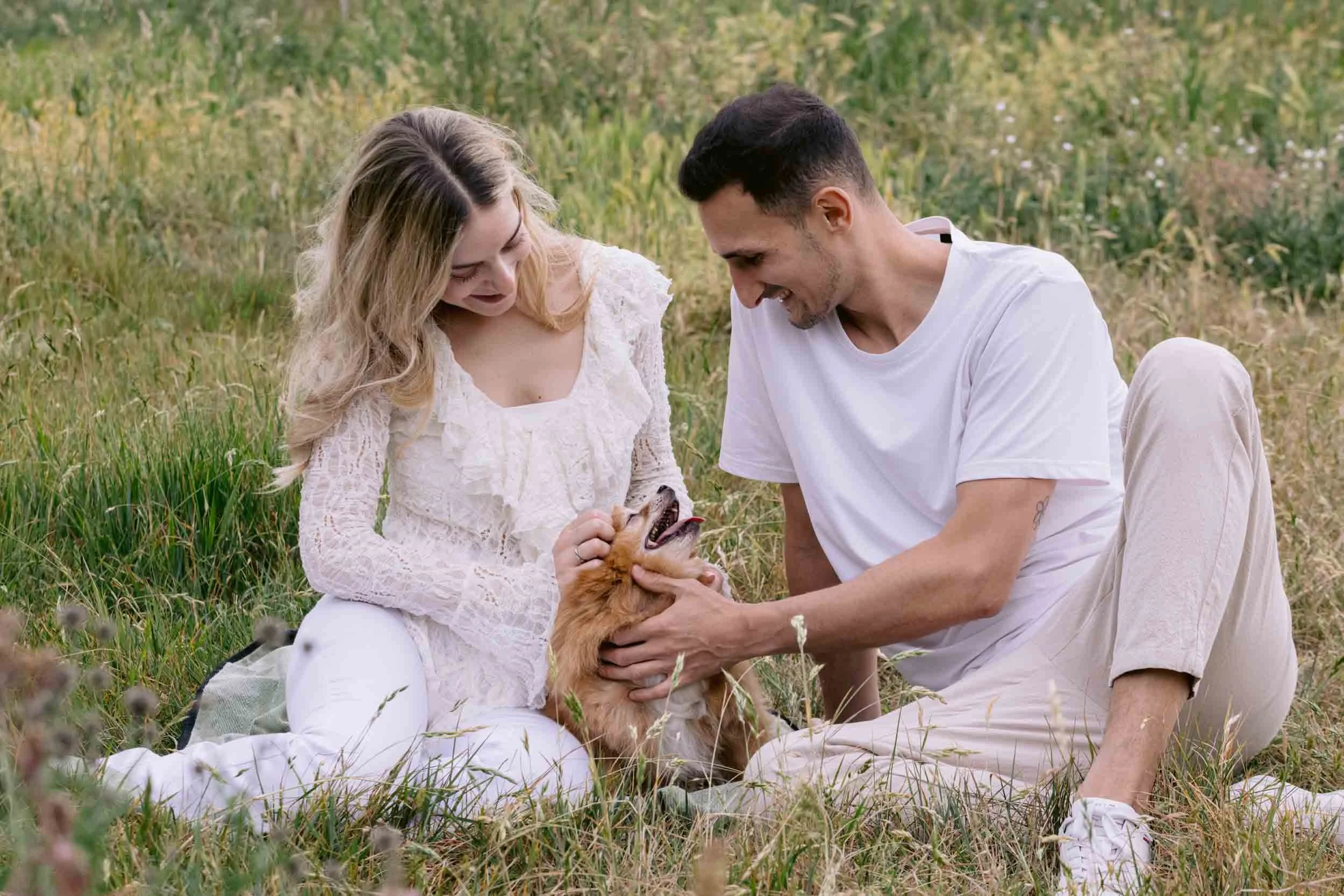 Couple cuddling their senior Pomeranian on Clapham Common