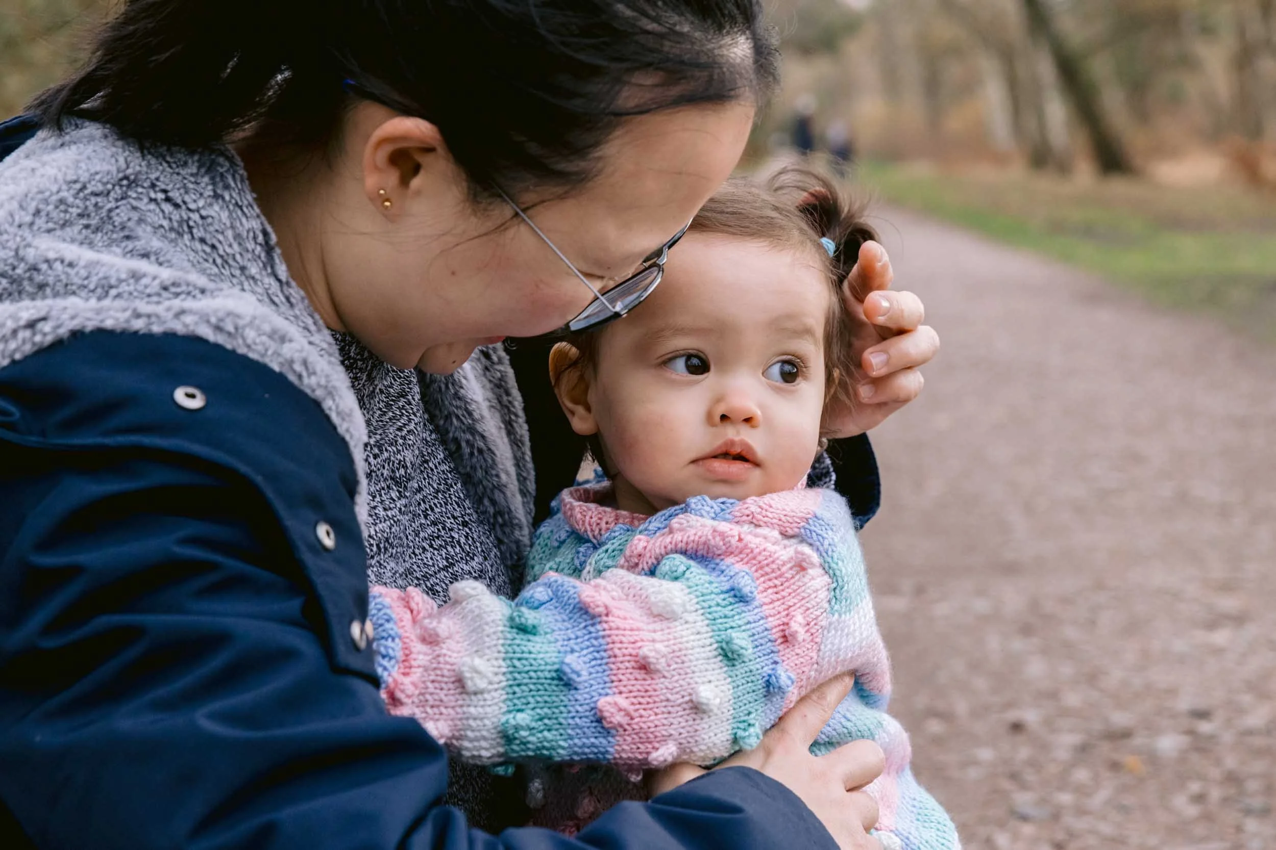 Mother hugging her toddler during a family photography session on Wimbledon Commmon
