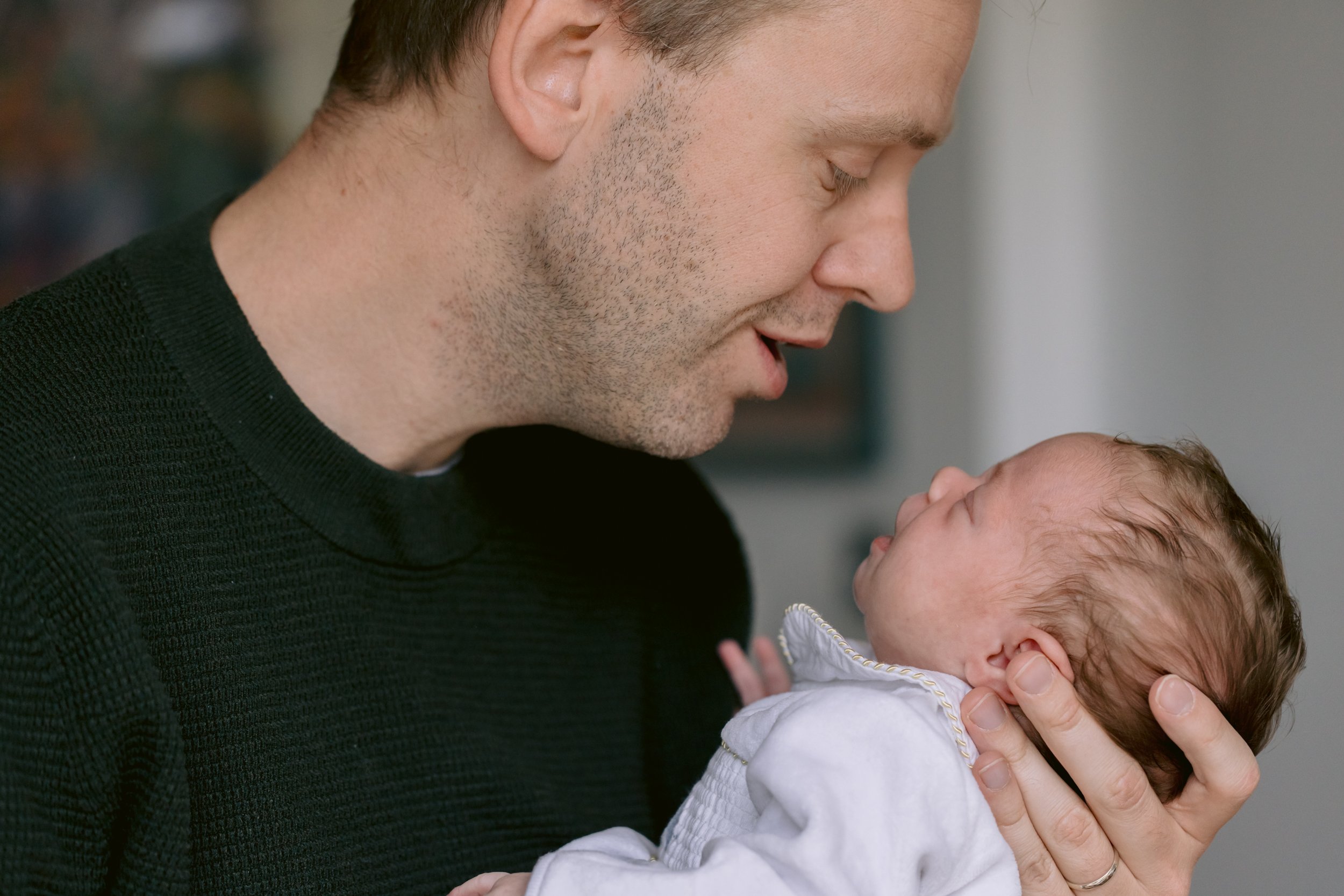 Dad putting baby to sleep during a newborn photo session in Putney