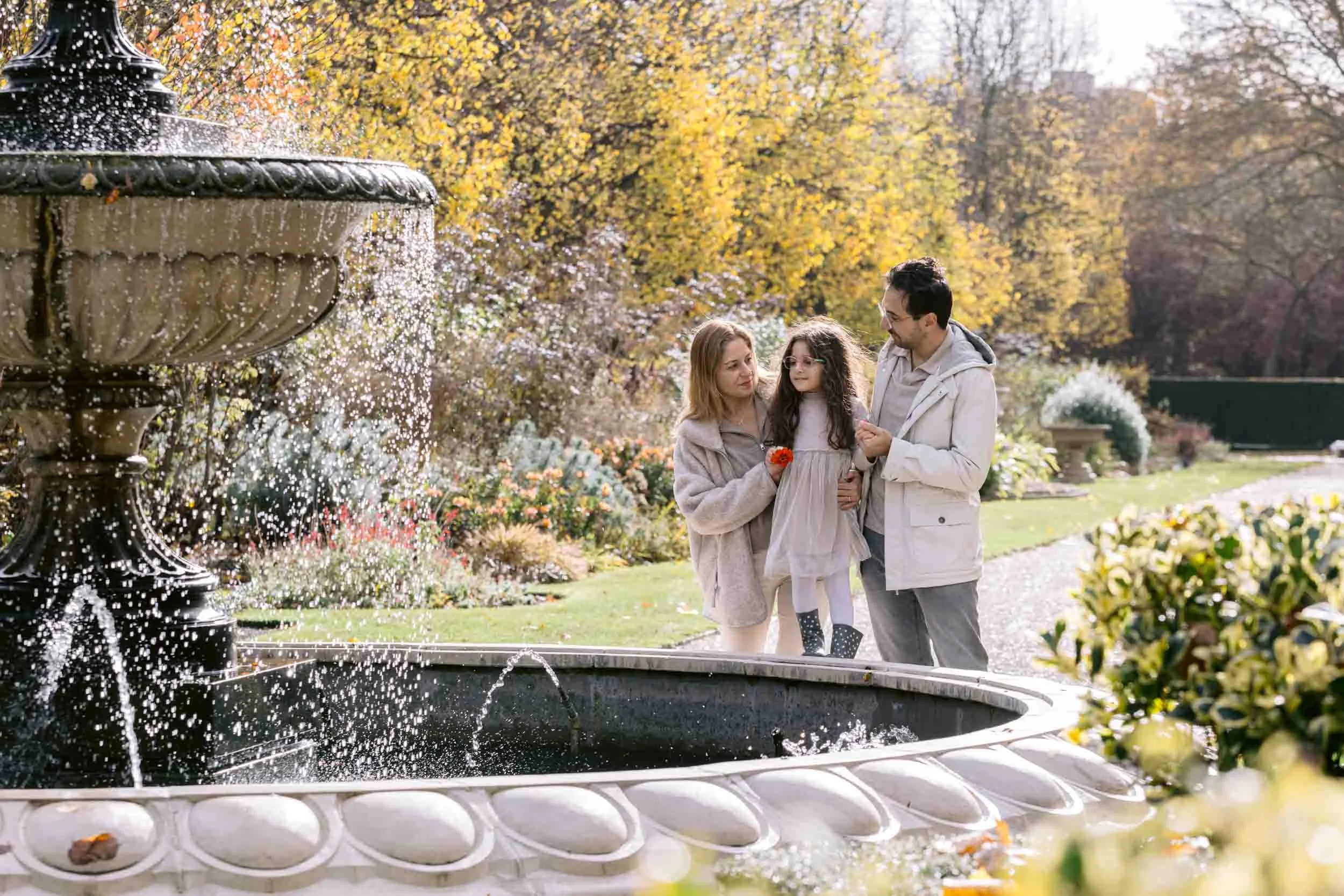 Family pausing by a fountain during Regent’s Park photoshoot