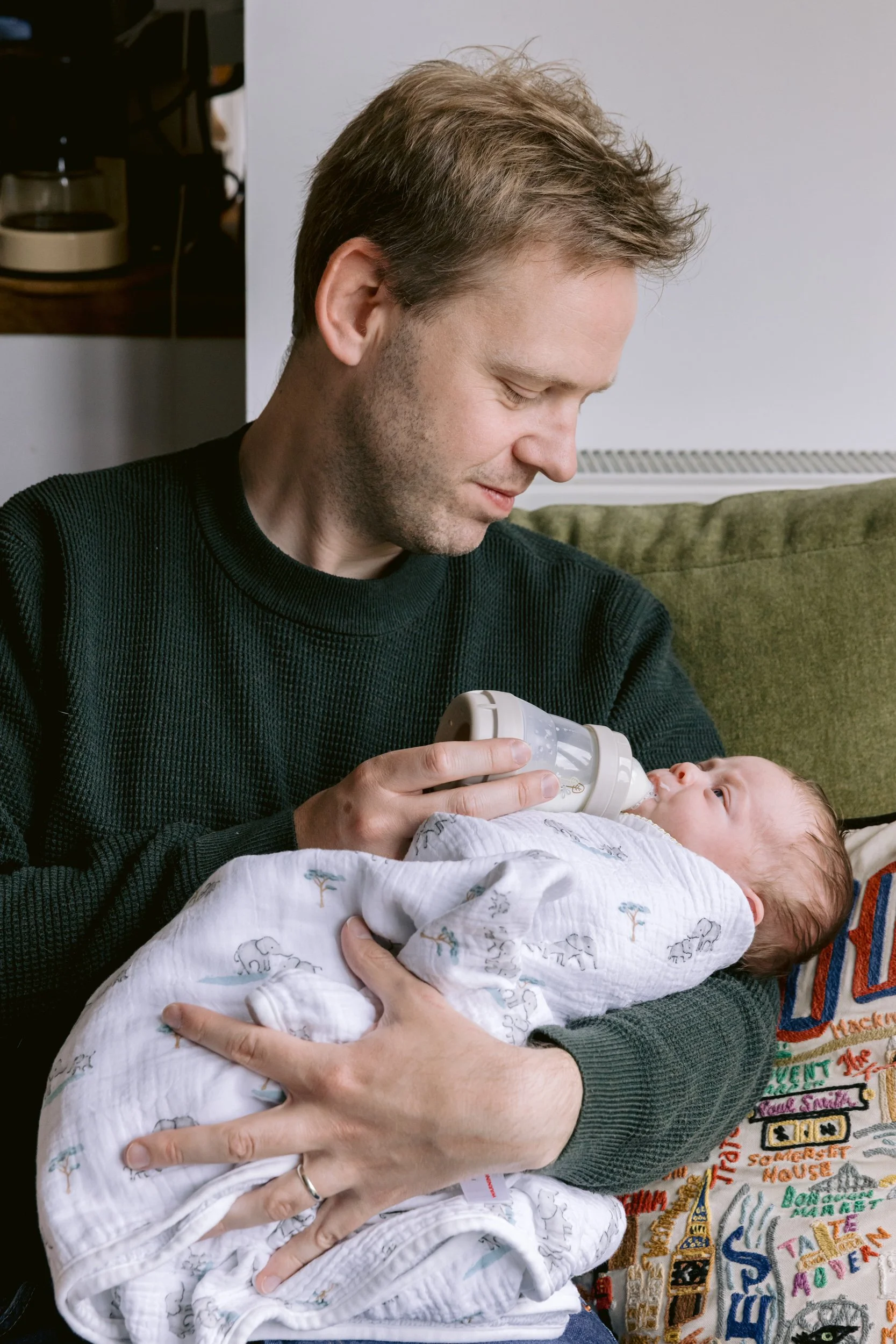 Dad bottle feeding a newborn baby during a newborn photoshoot in Putney, London