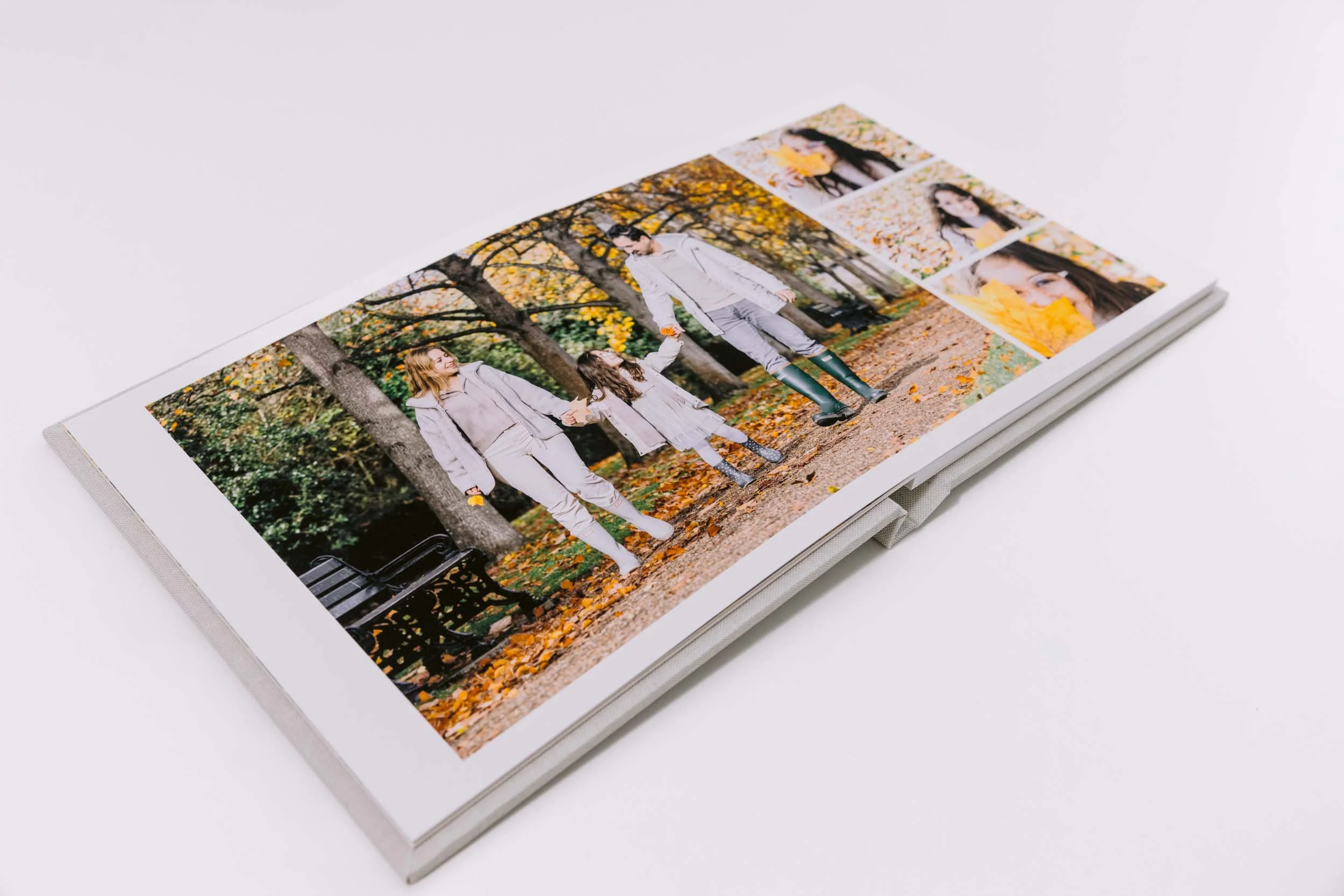 Open photo album showing pictures of a woman and a girl in a park during autumn. The images feature autumn leaves and trees.