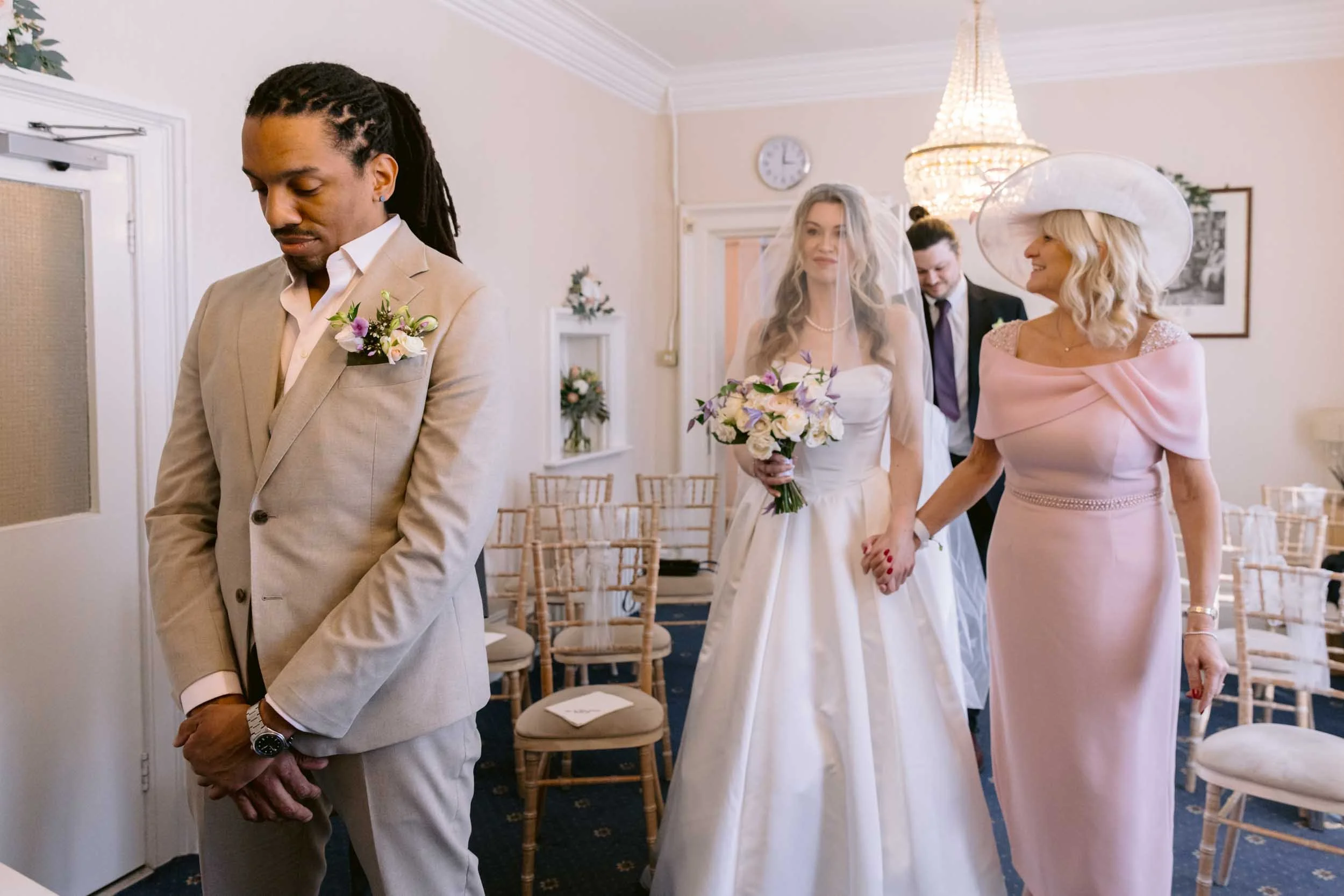 The bride and her mother walk down the isle at an intimate wedding ceremony at Guildford Register Office