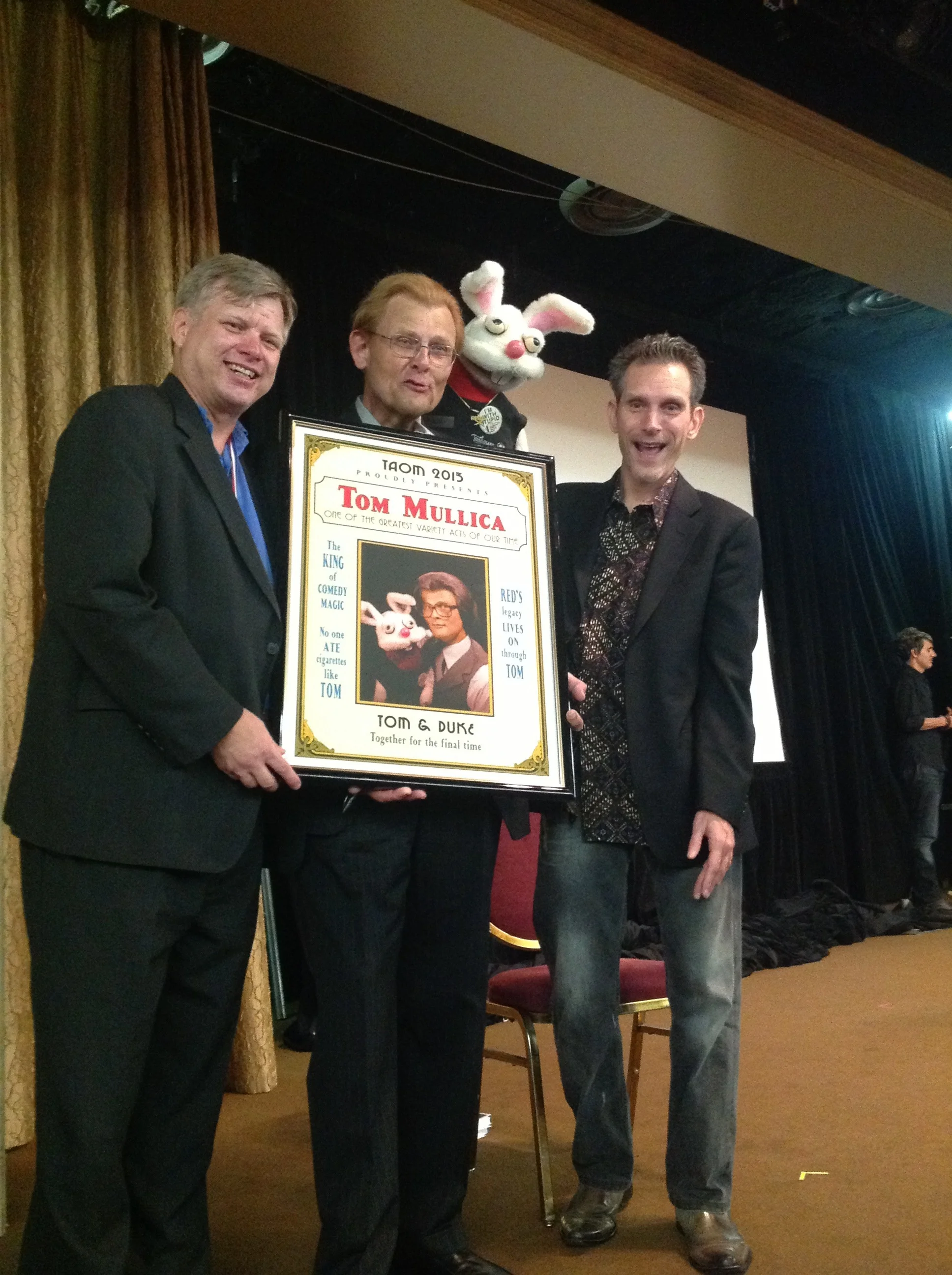 Tom Mullica accepts special poster from Mark Jensen and Chip Romero