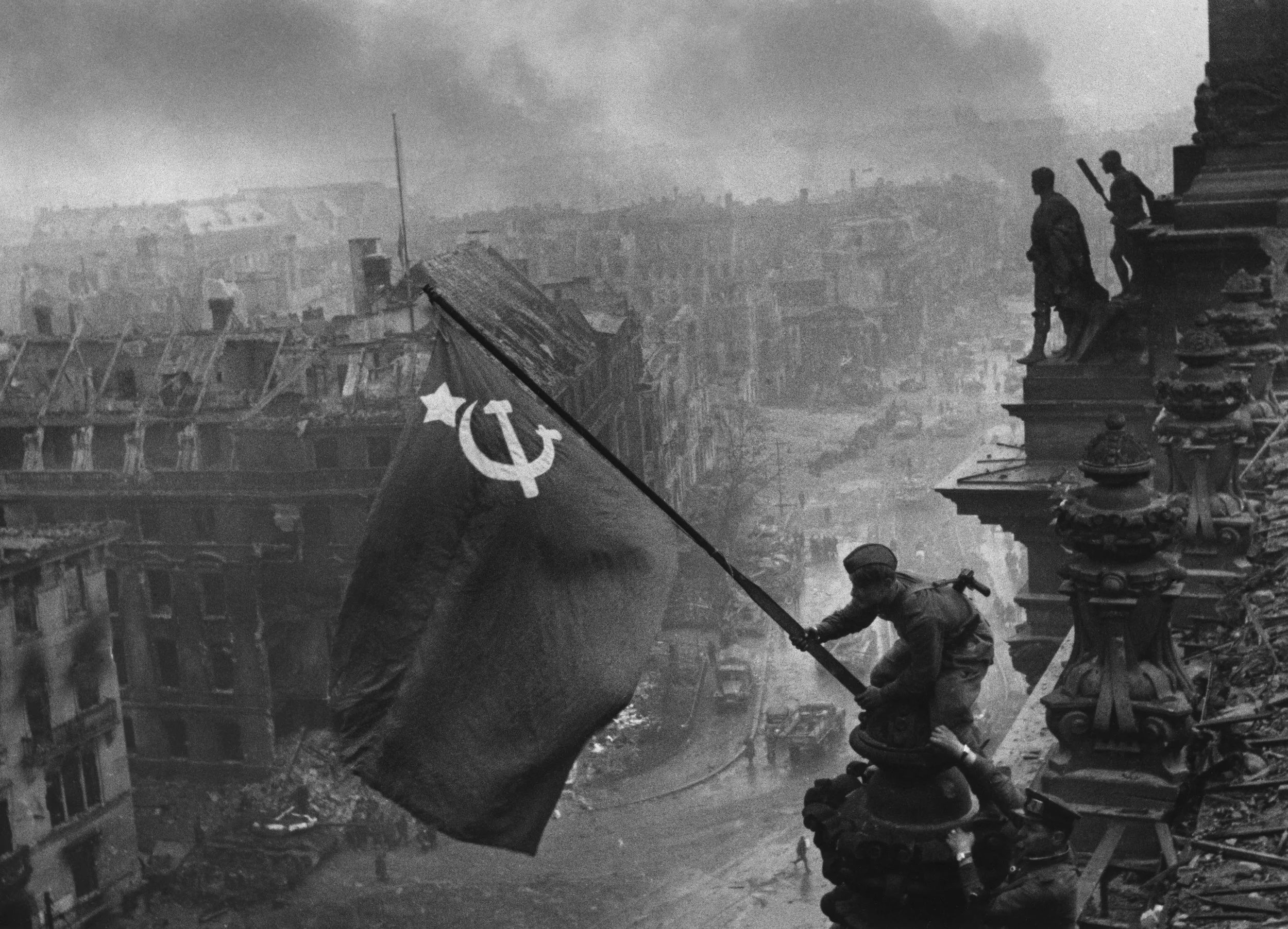 Soviet soldiers raise the hammer and sickle over the Reichstag during the Battle of Berlin on May 2nd, 1945. Photo credit: creative commons.