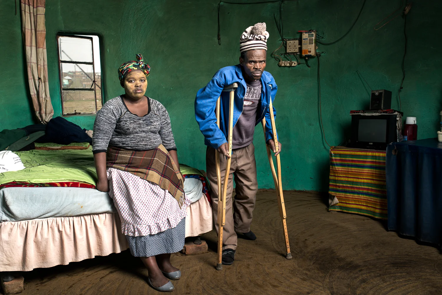 Patrick Sitwayi lives in Upper Mcambalala with his wife, five children and three grand children. He is 57 years old and has silicosis from working underground in the gold mines for 22 years. He did not receive any compensation for his illness and is unable to support his family without a job. He has to walk with crutches because his toes became infected and were amputated. He says that this is because of the primitive safety equipment and hot working conditions on the mines, causing excess sweating that collected in his plastic gumboots.