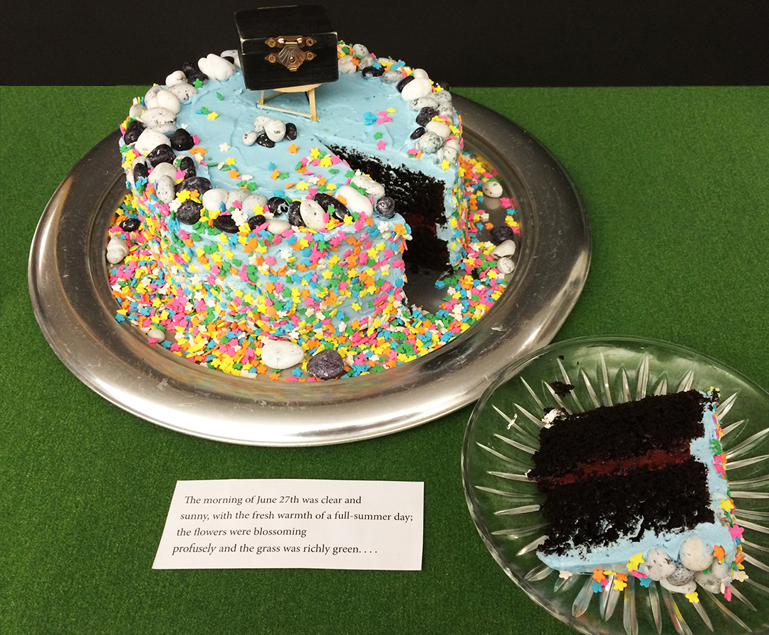 Two layers of black chocolate cake with blood-red filling and sky blue frosting. Adorned with a "profuse" amount of flower sprinkles, chocolate stones, a hand-made 3-legged stool, and an aged black box containing tiny slips of paper. Before the icing was applied, I slipped one large piece of paper onto which was placed a single smeared dot into the cake; a surprise for one taster.
