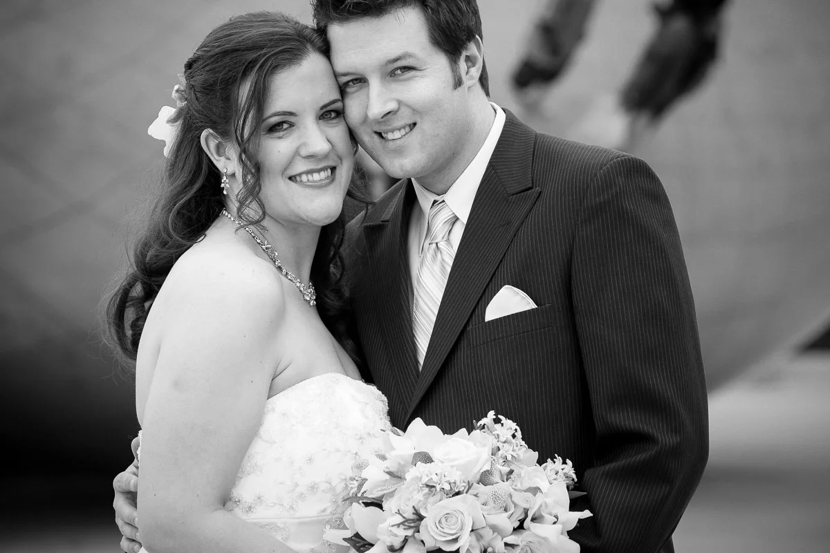 Wedding couple poses for a portrait in front of the Bean at Millennium Park. 