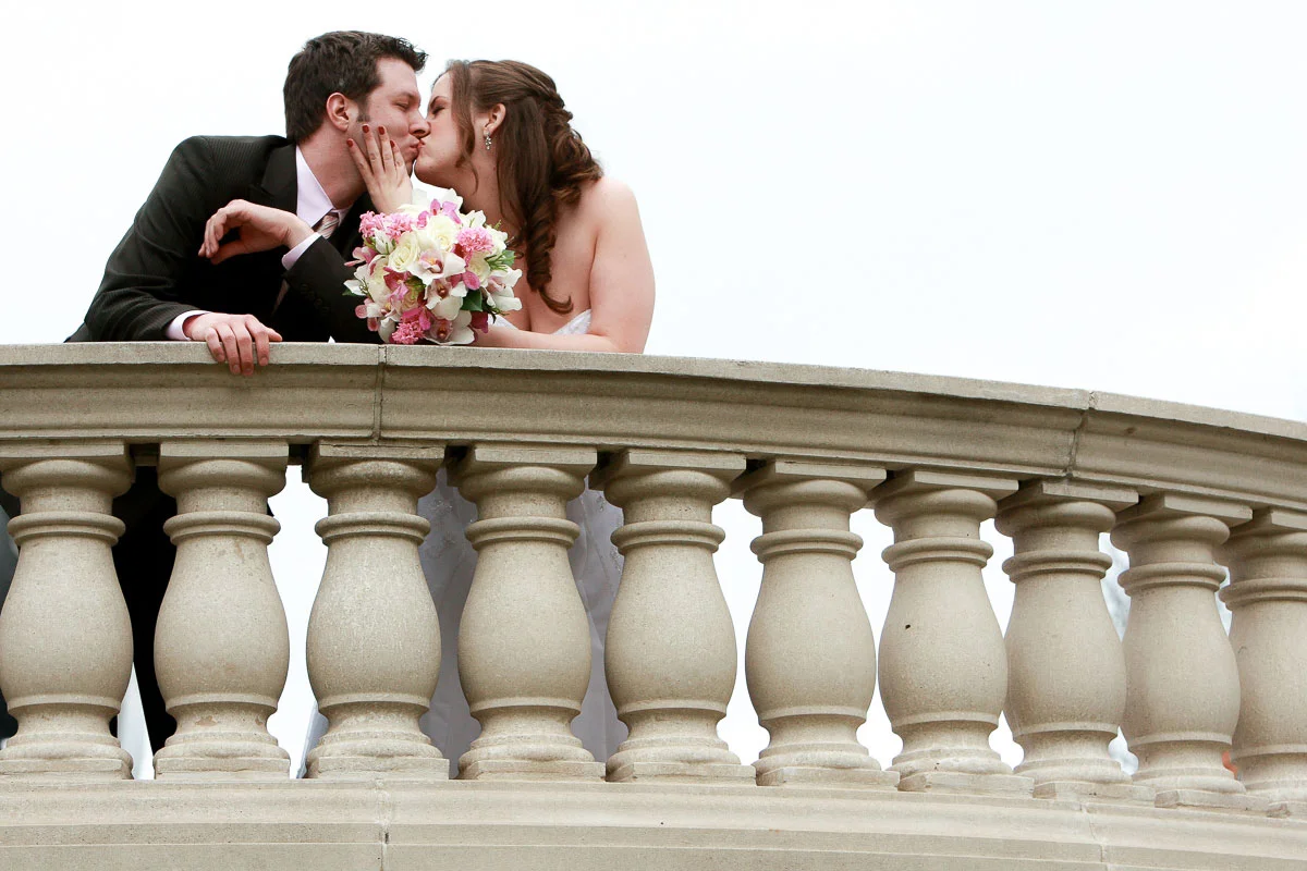 Wedding couple kisses near the entry way to Millennium Park. 