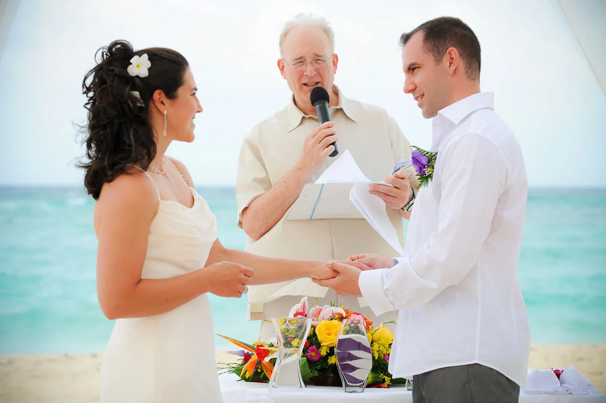 Bride and groom exchange rings during their wedding ceremony at the Majestic Colonial Resort, Punta Cana.