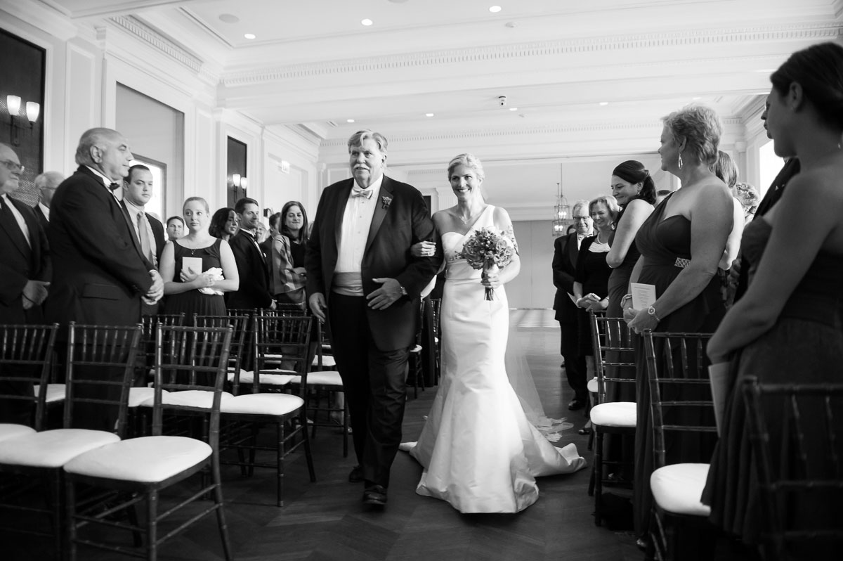 Bride walks down the aisle with her father during her wedding at the Chicago History Museum. 