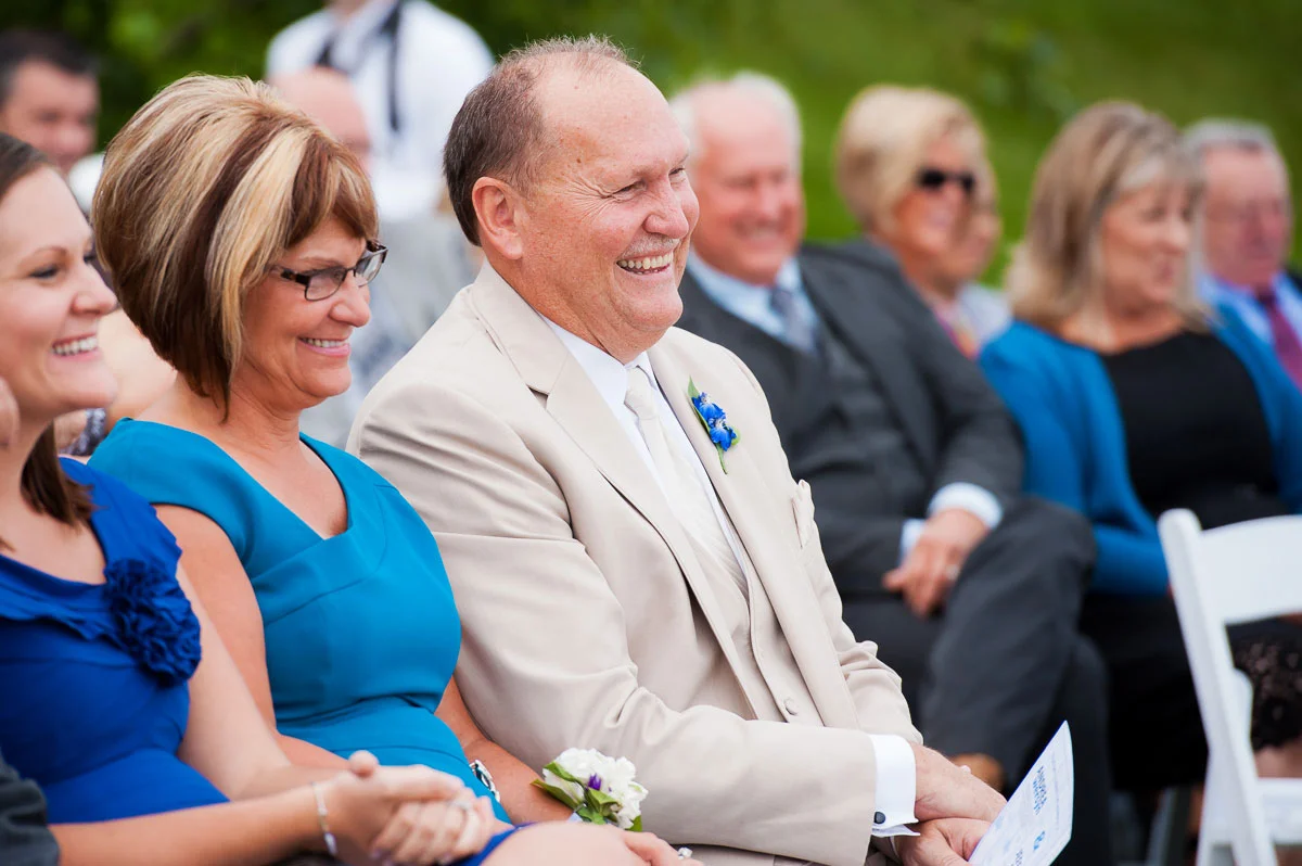 Father-of-the-bride smiles during his daughter's wedding at Blue Harbor Resort.