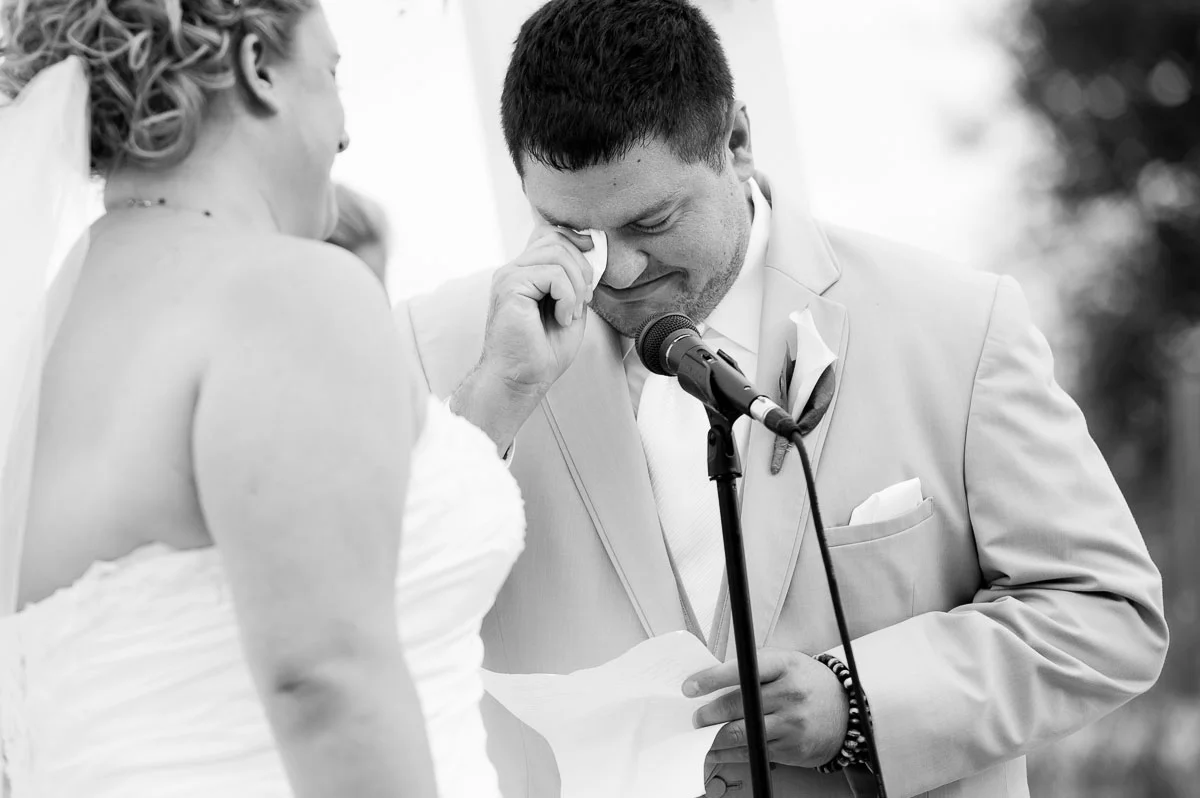 The groom cries as he reads his vows at a wedding ceremony at Blue Harbor Resort. 