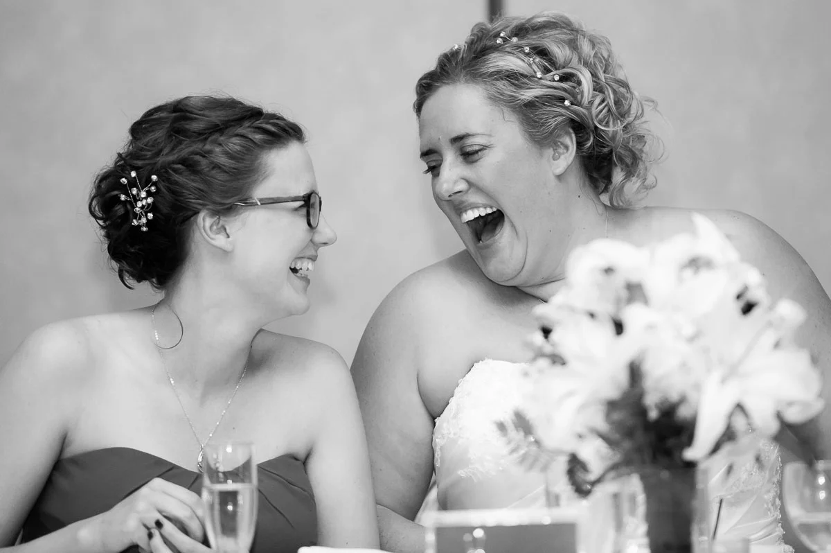 The bride and maid-of-honor share a laugh during a wedding reception at Blue Harbor Resort. 