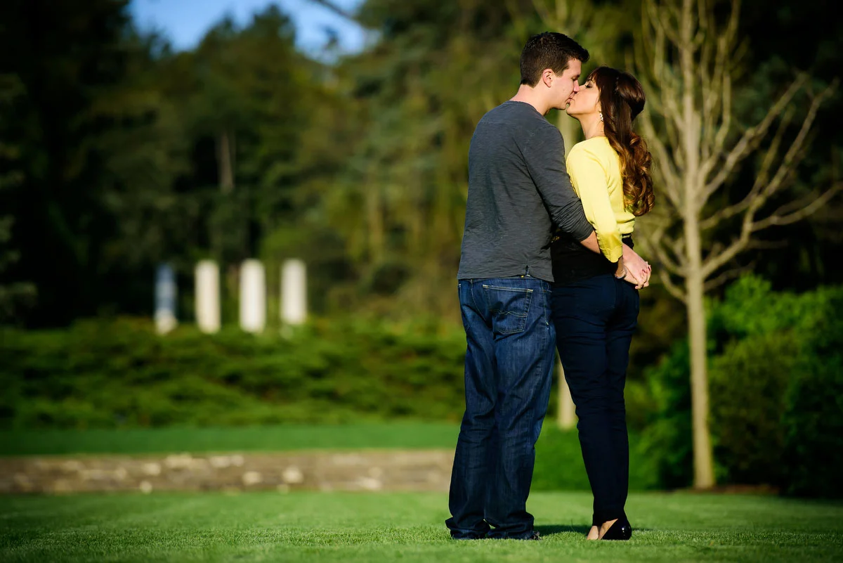 A couple kisses during their engagement session at the Morton Arboretum in Lisle, IL. 
