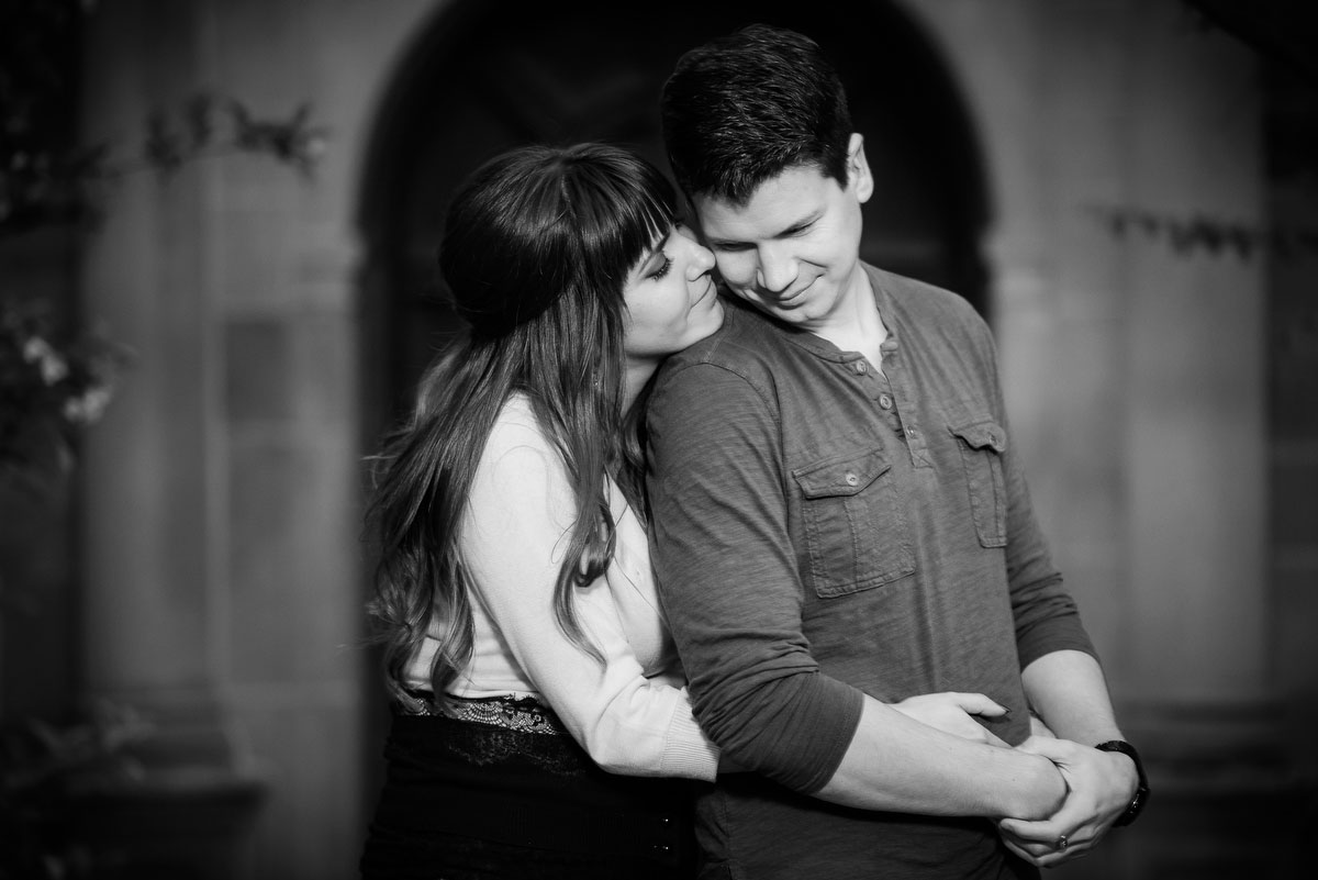 A couple holds one another outside the Thornton building at the Morton Arboretum during their engagement session. 